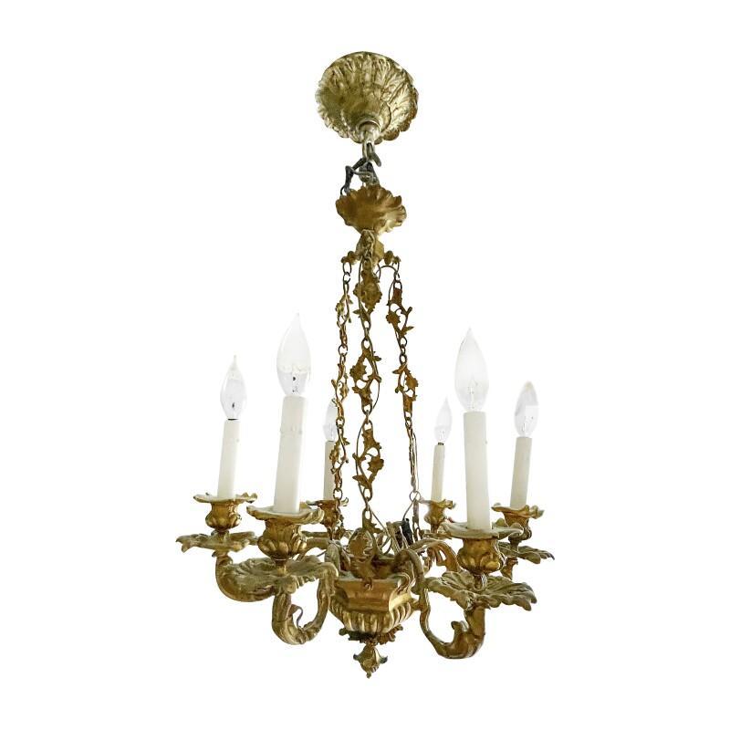 Louis Philippe style six-light chandelier.
Bronze construction.
Later conversion to electricity.
Hangs slightly tilted.
Exposed wires wrapped in black electrical tape.
Not examined off ceiling.
