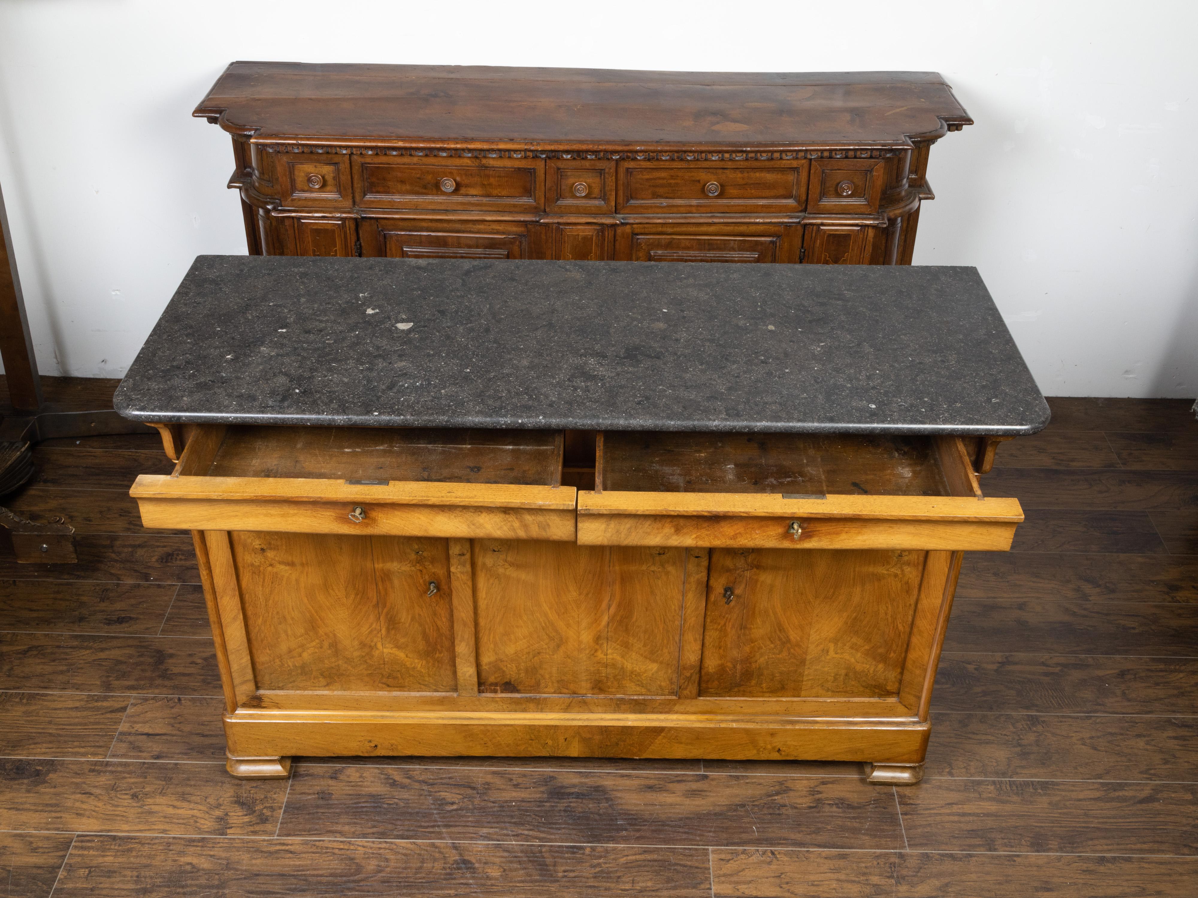 A French Louis-Philippe style walnut enfilade from the late 19th century, with marble top and two drawers over two doors. Created in France during the third quarter of the 19th century, this walnut enfilade features a rectangular dark grey marble