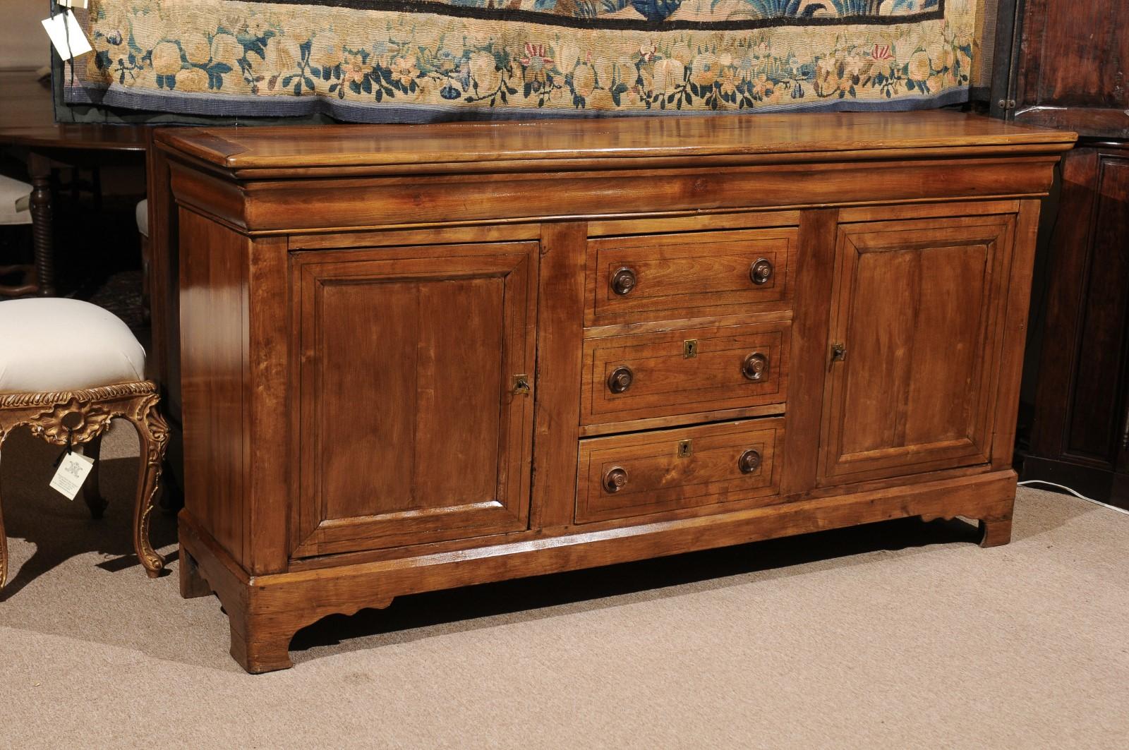 The French Louis Philippe style fruitwood Enfilade with ebonized string inlay, 3 drawers with turned wooden knobs, 2 flanking cabinets ending in bracket feet.
