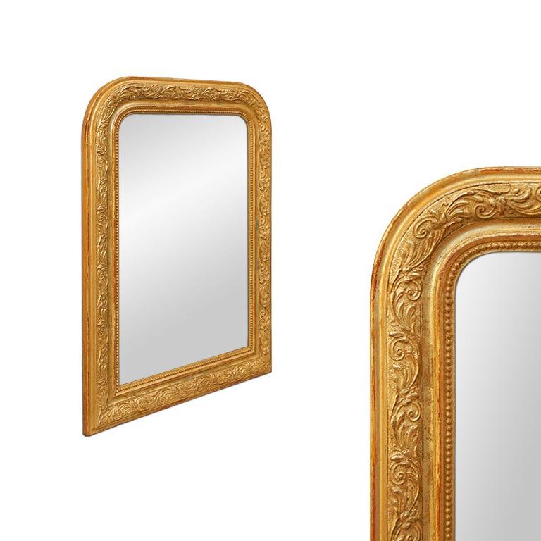 Miroir ancien français en bois doré, de style Louis-philippe avec des ornements de feuilles et de perles. Re-dorure sur la feuille patinée. Miroir en verre moderne. Largeur du cadre ancien : 8 cm.