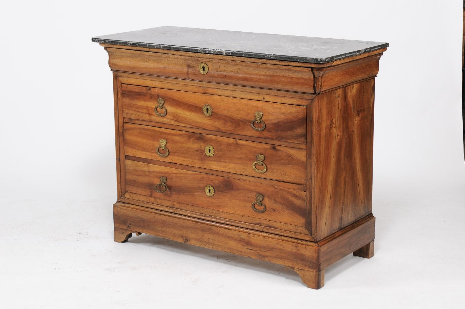A French Louis-Philippe walnut commode from the late 19th century, with grey marble top and four drawers. Born in France during the later years of the 19th century, this pretty Louis-Philippe commode features a gorgeous veining in the marble top