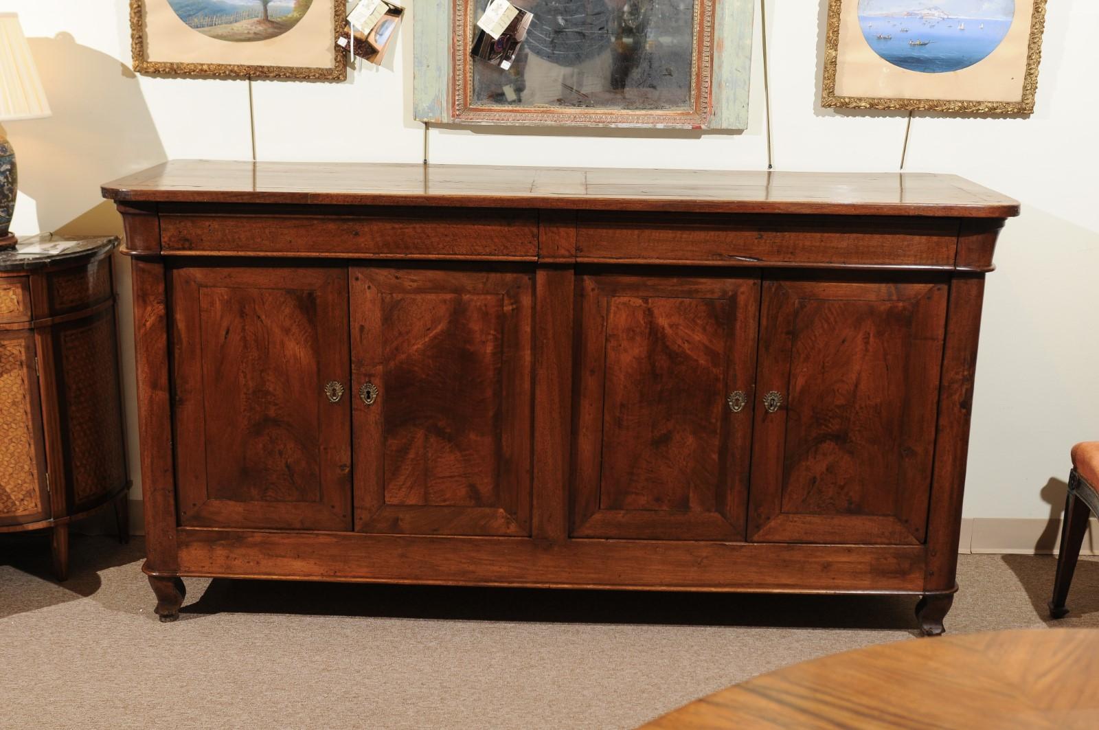 French Louis Philippe enfilade with a nice medium walnut patina, two long drawers, four cabinet doors below and carved curved feet.