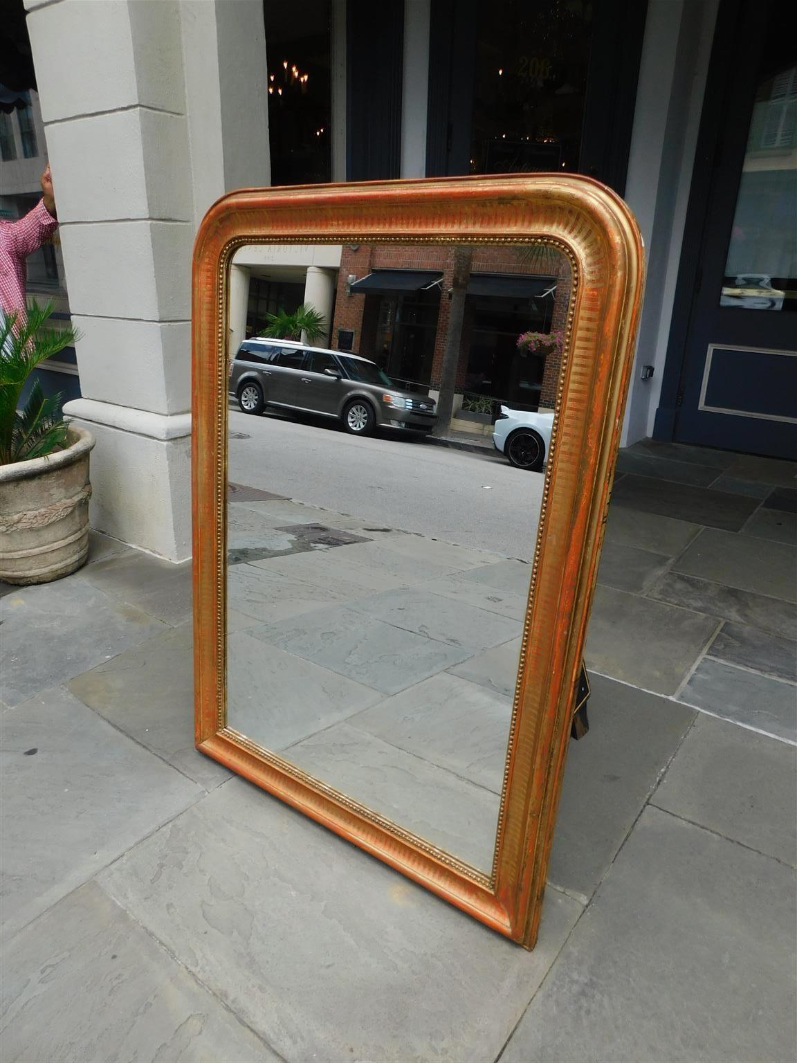 French Louis Phillipe gilt wood and gesso hand etched interior beaded wall mirror, Early 19th Century. Mirror retains the original silvered glass and wood backing. 