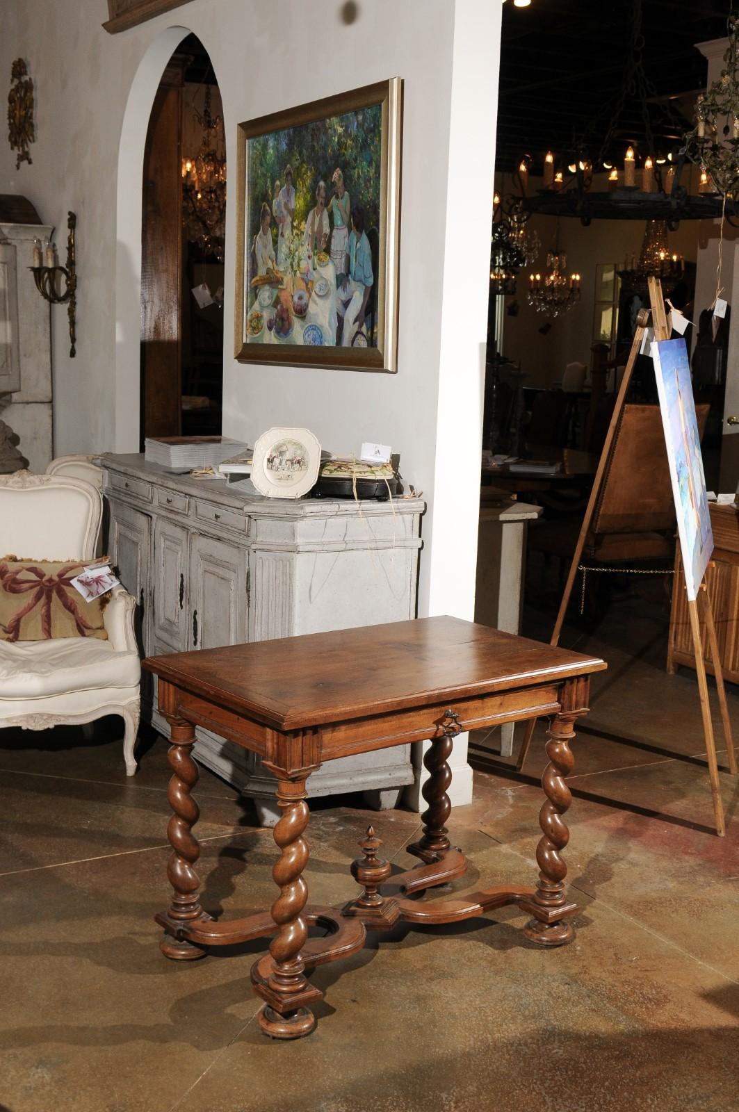 A French Louis XIII style walnut table from the early 19th century, with barley-twist legs, single drawer and X-form cross stretcher. Born in France during the Napoleonic era, this exquisite table presents the stylistic characteristics of the Louis