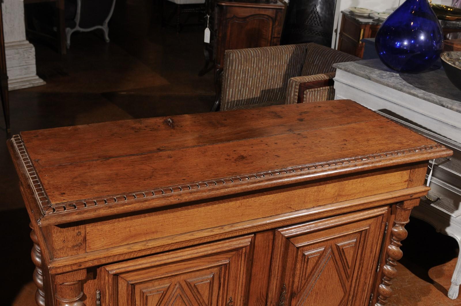 A French Louis XIII style oak buffet from the mid-19th century, with diamond motifs and barley twist columns. Born in France during the reign of Emperor Napoleon II, this oak buffet presents the stylistic characteristics of the Louis XIII era. The