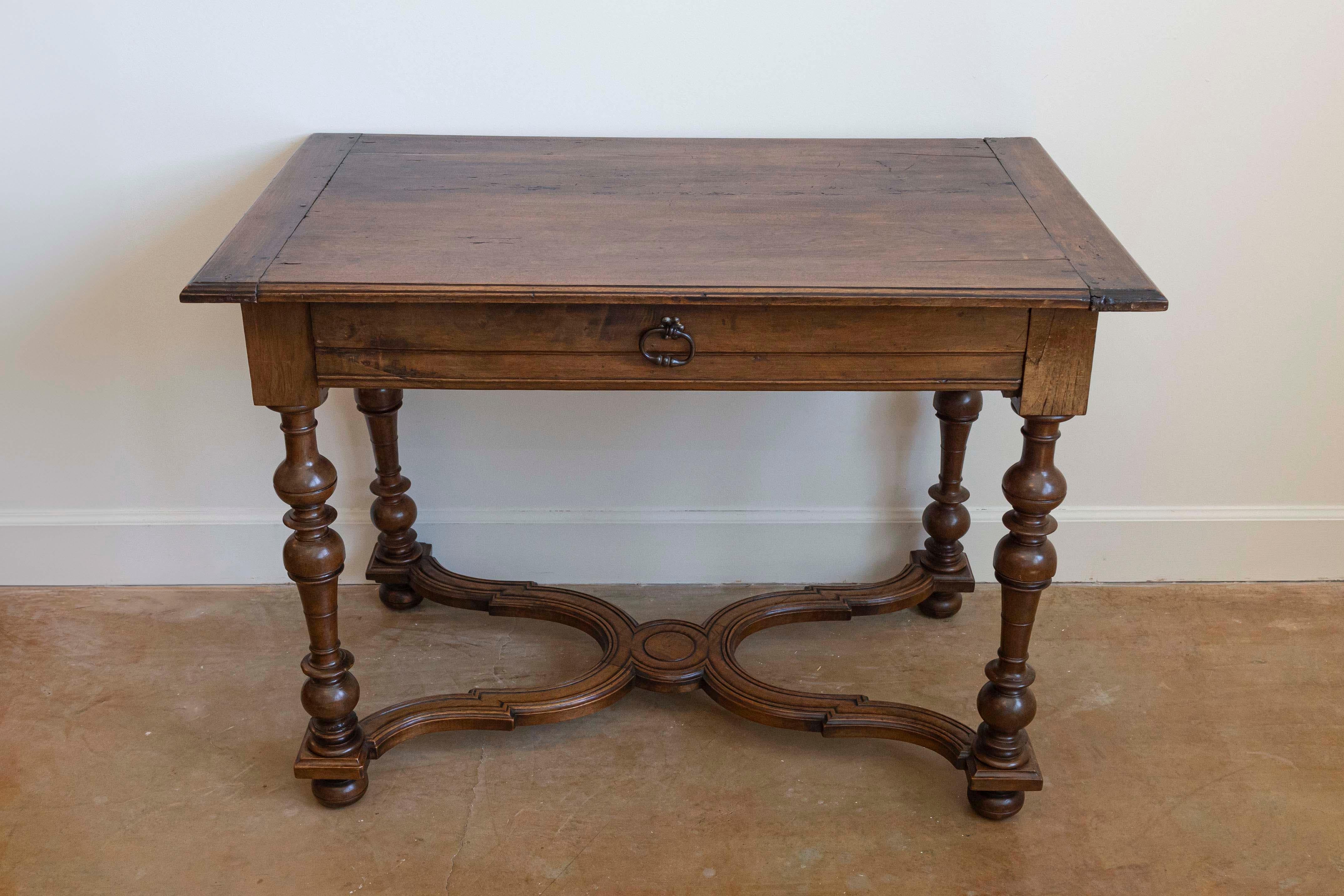 A French Louis XIII style walnut side table from the late 19th century, with baluster legs, single drawer and X-Form cross stretcher. Created in France during the last quarter of the 19th century, this walnut side table showcases the stylistic