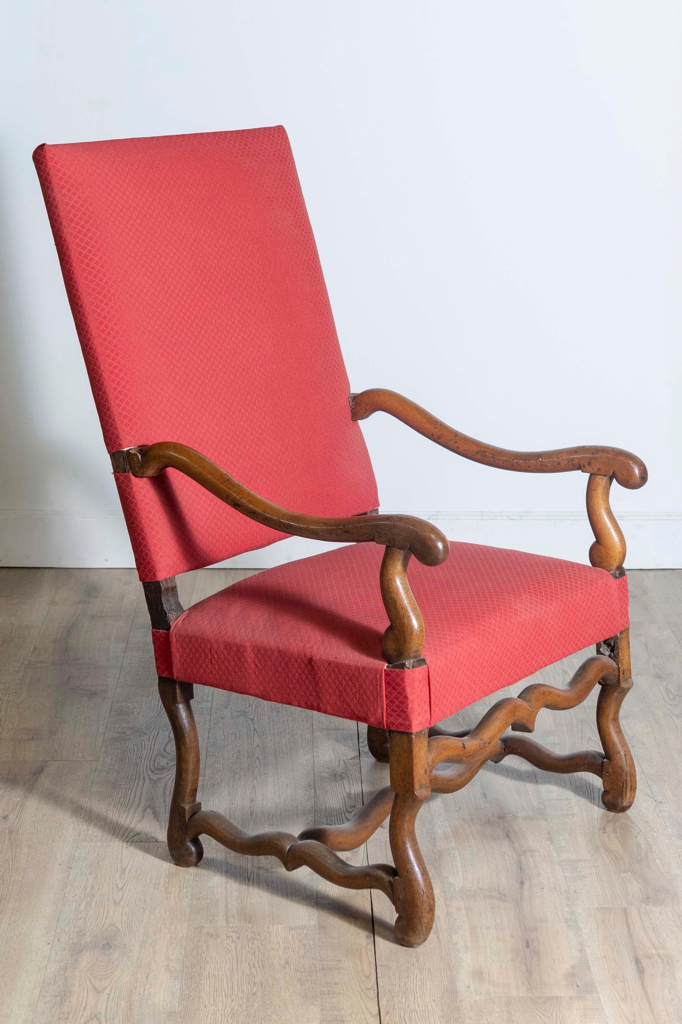 Fauteuil francés de nogal del siglo XIX, estilo Luis XIII, con base de Os de Mouton, grandes brazos con volutas y tapicería roja. Creado en Francia durante el siglo XIX, este sillón de nogal muestra las características estilísticas de la época de