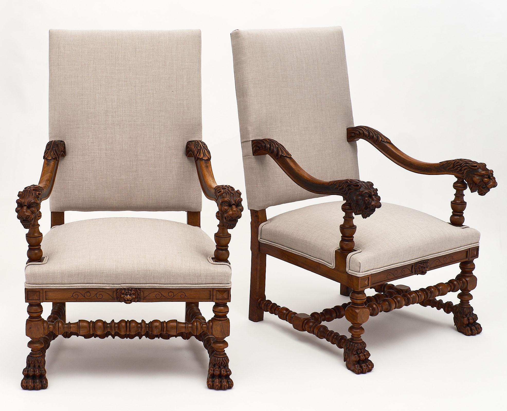 Louis XIII style French armchairs made of finely hand carved walnut. We love the intricate details of the lion heads on the armrests, and paws on the feet. These chairs are very comfortable with fantastic proportions. They have been newly