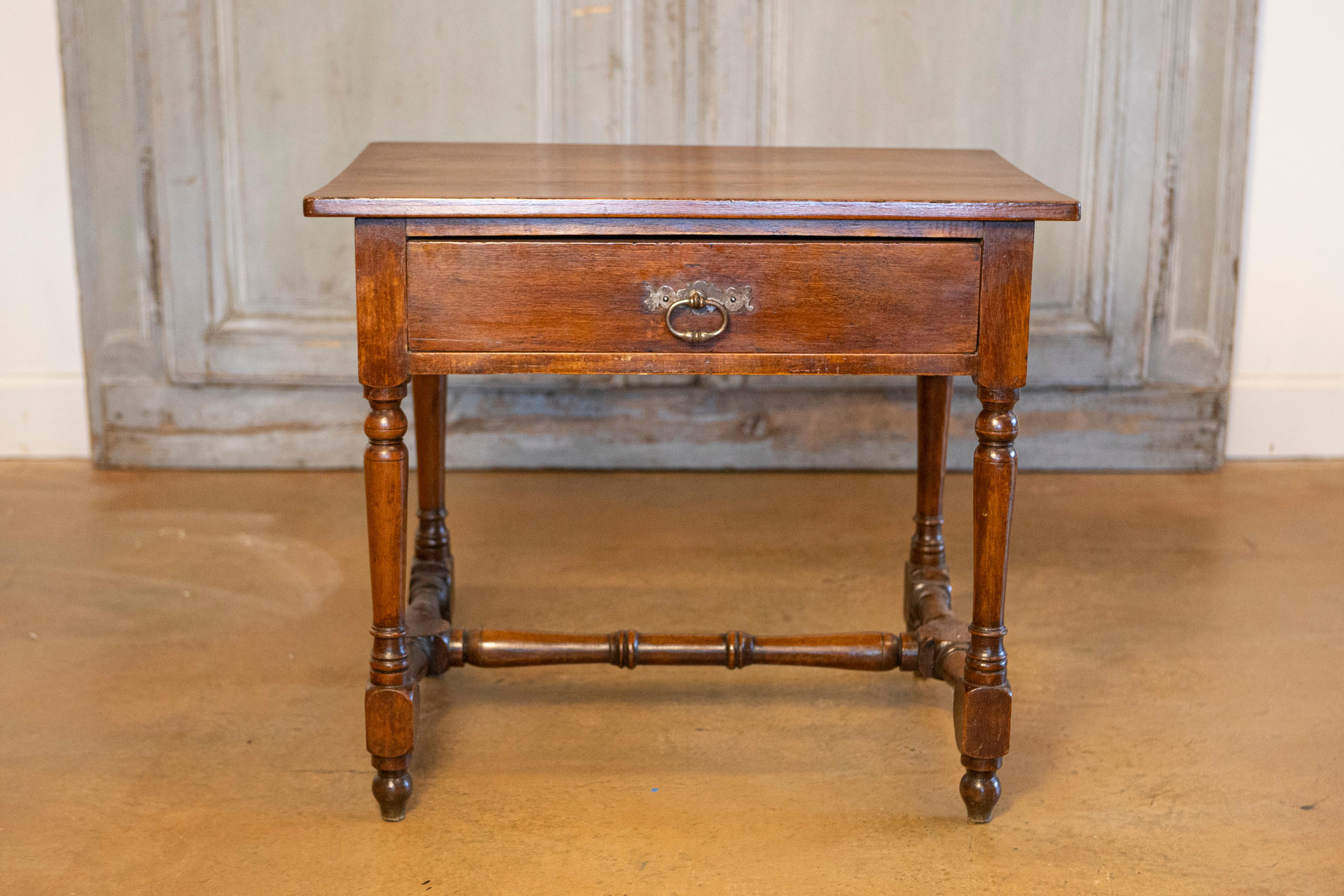 A French Louis XIII style side table from the late 19th century, with single drawer, turned base and H-form cross stretcher. Born in France during the later years of the 19th century, this Louis XIII style table features a rectangular top sitting