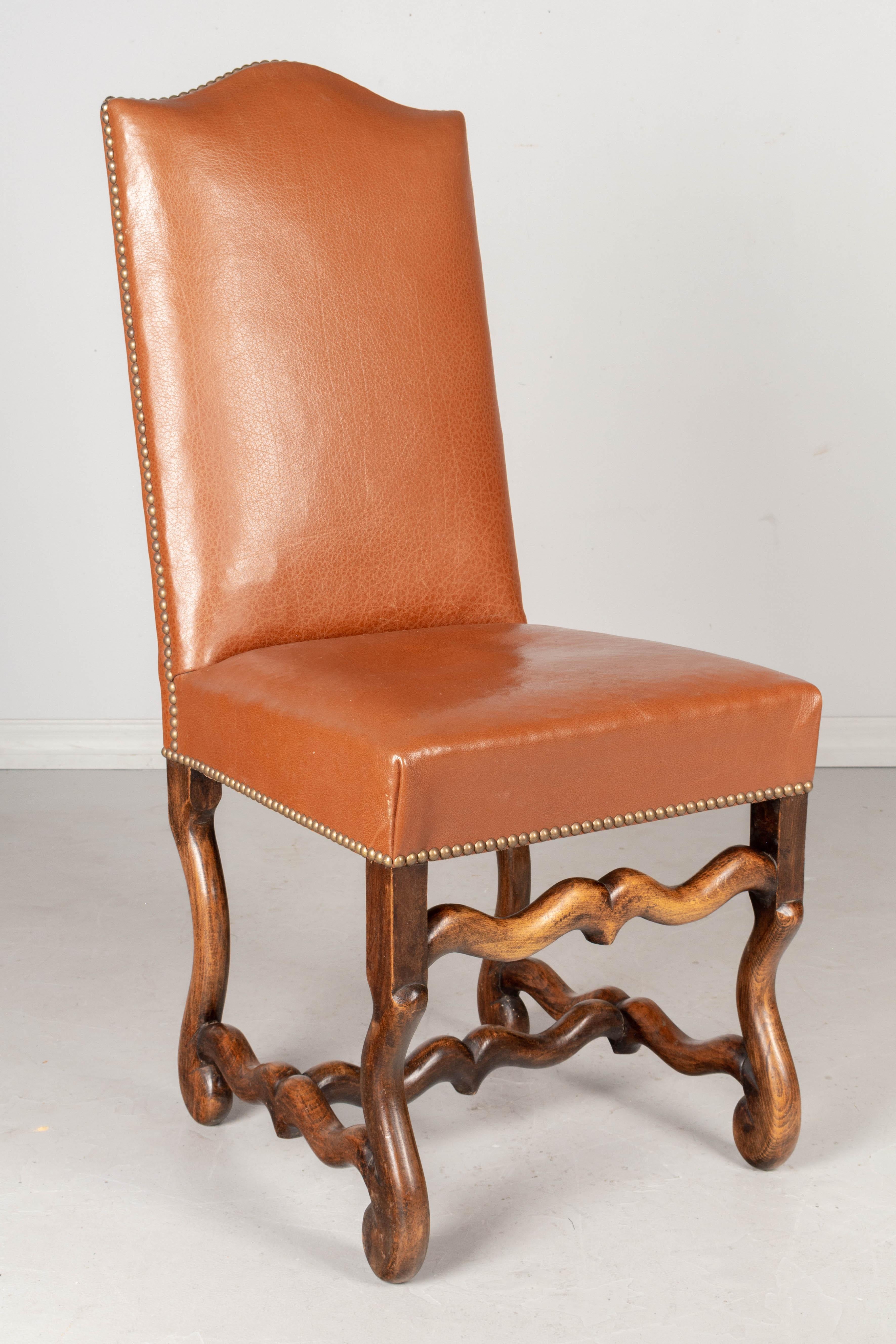 Ensemble de huit chaises de salle à manger de style Louis XIII, avec de solides châssis en bois de hêtre, un haut dossier arqué et des pieds sculptés en os de mouton. Sellerie en cuir d'origine avec garnitures en têtes de clous, en état de marche.
