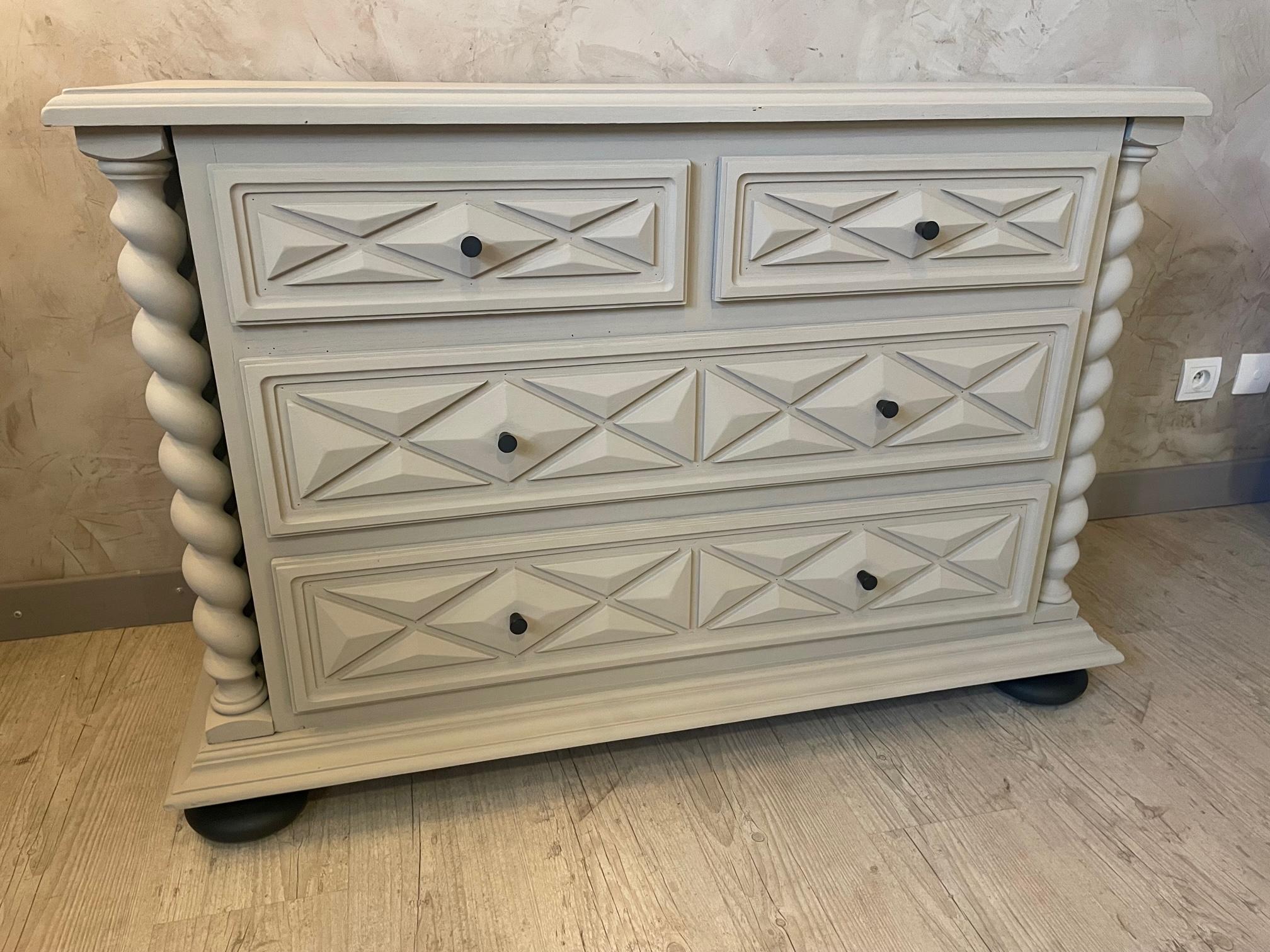 Beautiful 20th century French commode in the style of Louis XIII with two turned column and four drawers with diamond pattern. 
We wanted to give this chests of drawers a modern look in painting it and changing the handles with light metal handles.
