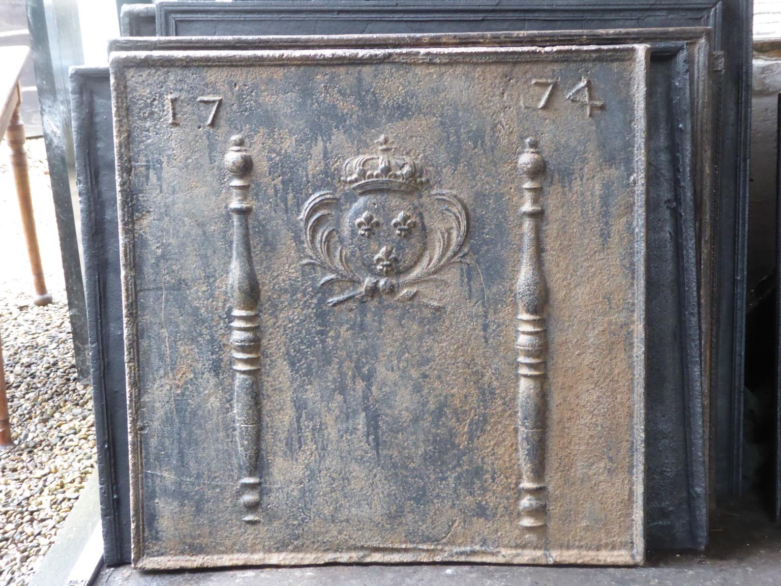 Beautiful 18th century French Louis XIV fireback with the arms of France. The Arms of France are flanked by two Pillars of Hercules, which symbolize strength and the unknown. The date of production of the fireback, 1774, is also cast in the