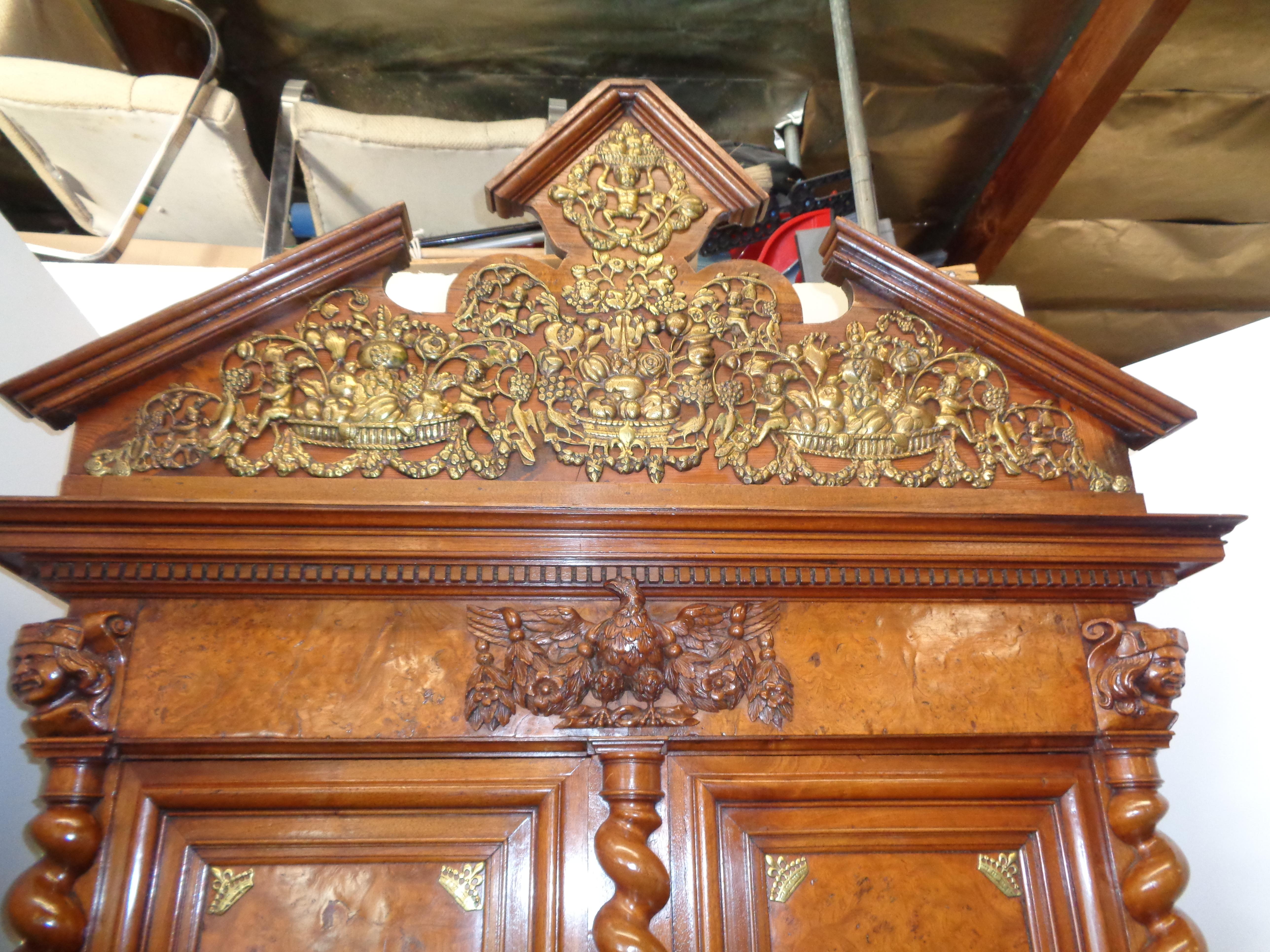 This rare buffet deus corps has a slanted pediment top adorned with heavy bronze mounts depicting baskets of fruit. Above the burled elm cupboard doors at the center is a magnificent three dimensionally carved eagle. Each door is flanked by three