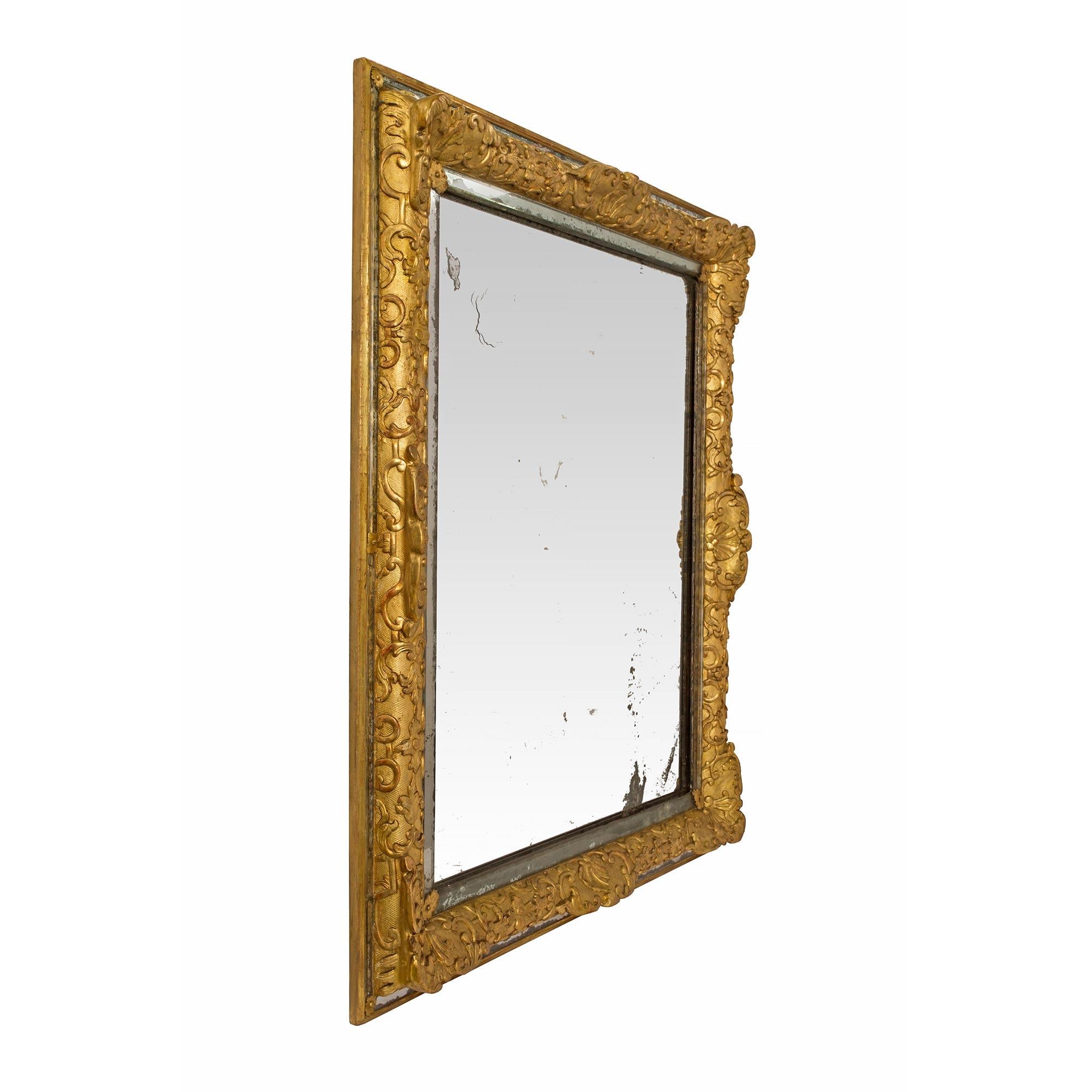 A sensational and extremely elegant French Louis XIV period mid 17th century Circa. 1660 double framed mirror. The central mirror plate is bordered by slender filets of beveled mirror plates and gilt metal rosettes at each corner. The bold mottled