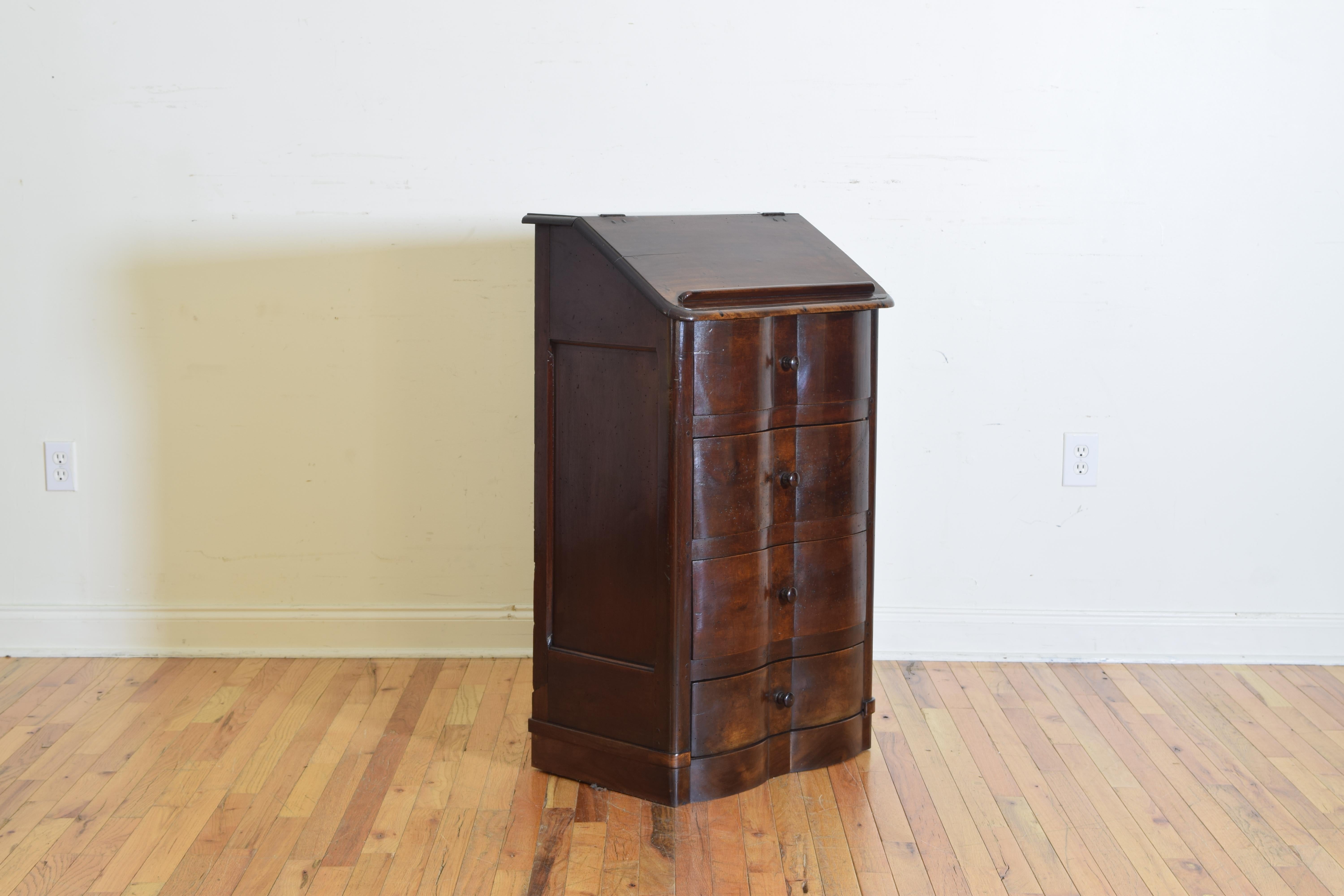 Having a slanted and hinged top with a raised bookrest opening to reveal a storage area, the conforming case housing 4 drawers and having a serpentine profile, the bottom drawer with a false (secret) top.