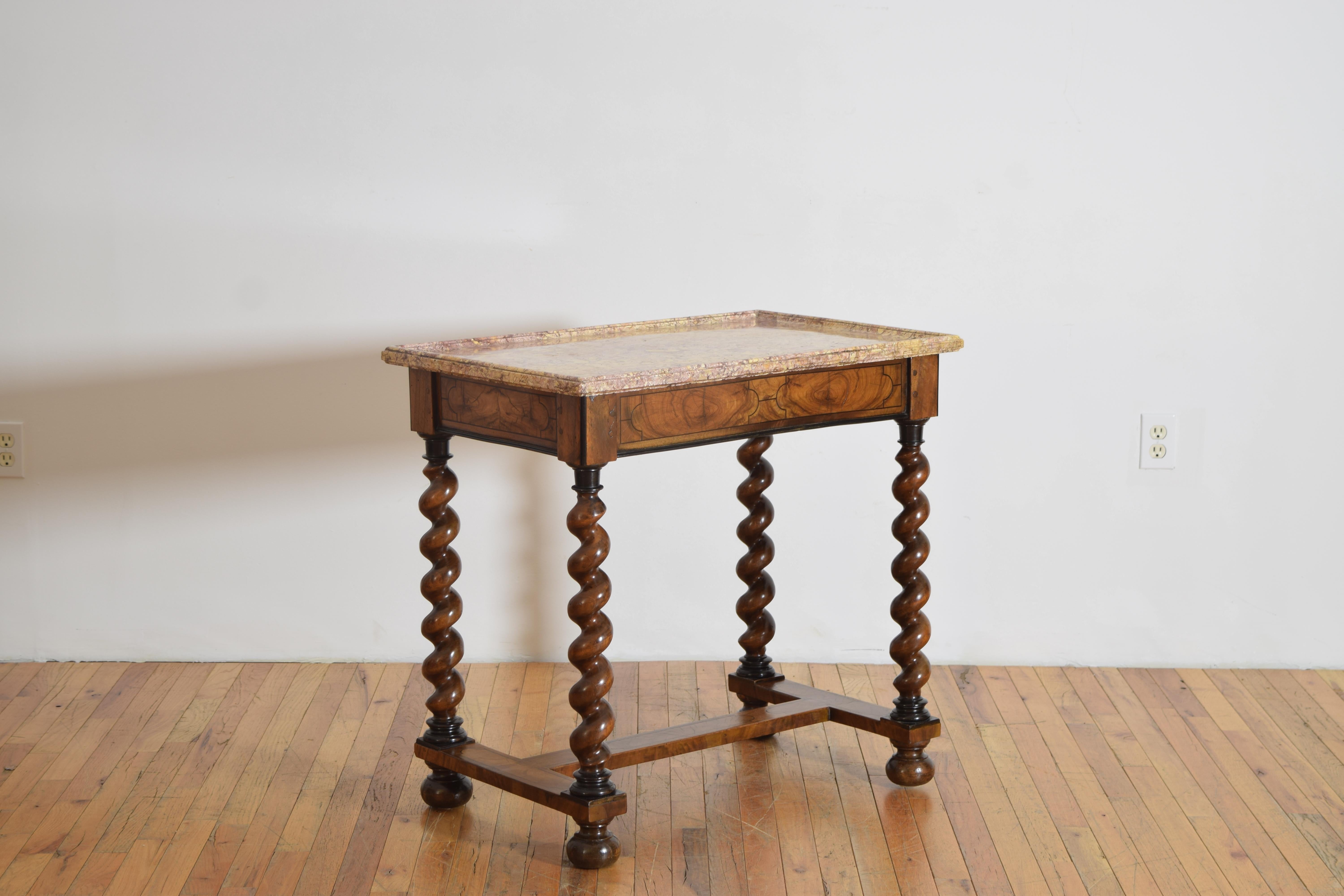 Questo tavolo, che conserva l'originale piano a vassoio in marmo sagomato, è costruito interamente in noce e presenta gambe sapientemente tornite che sostengono la cassa impiallacciata a 1 cassetto, le gambe sono unite da una barella piatta a forma