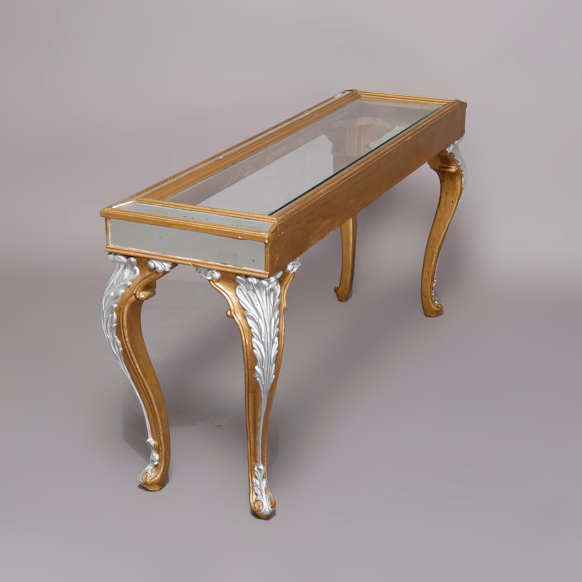 Vintage French Louis XIV style sofa table offers carved base with faceted top having glass with mirrored borders in gold gilt frame with raised on cabriole legs having silver gilt knees and feet, 20th century


Measures: 26.25