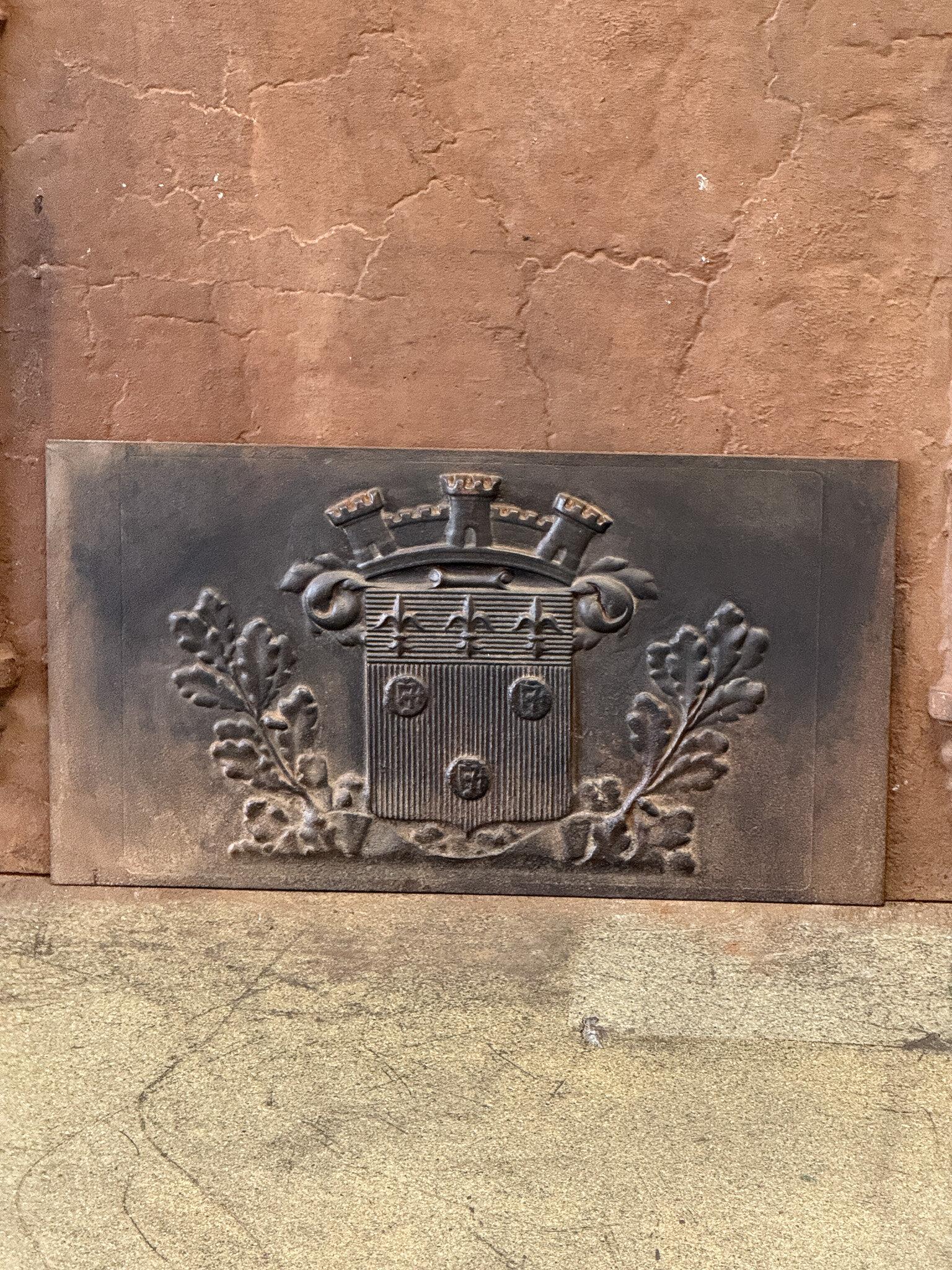 20th century Louis XIV style fireback with a coat of arms.

The fireback is made of cast iron and has a natural brown patina. Upon request, it can be made black/pewter colored with stove polish at no extra cost. It is in good condition and does not