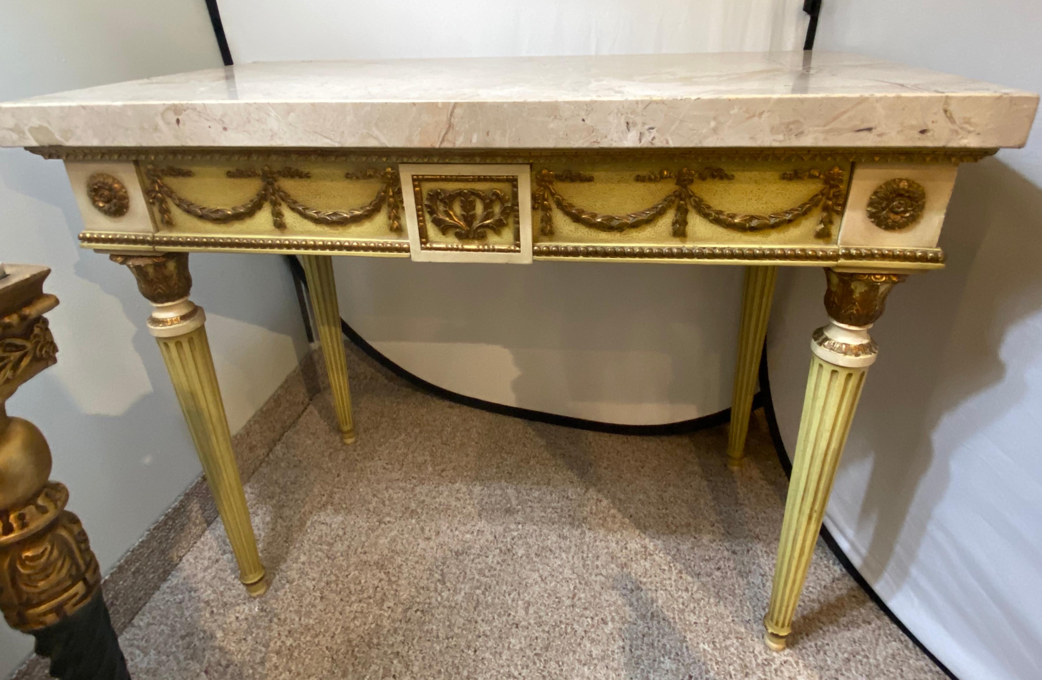 French Louis XIV style console table, the rectangular marble atop a narrow frieze fitted with two drawers, decorated with parcel-gilt carvings on ribbons and patera, raised on four fluted tapering legs ending in tapered feet. Stunning Creme two Inch