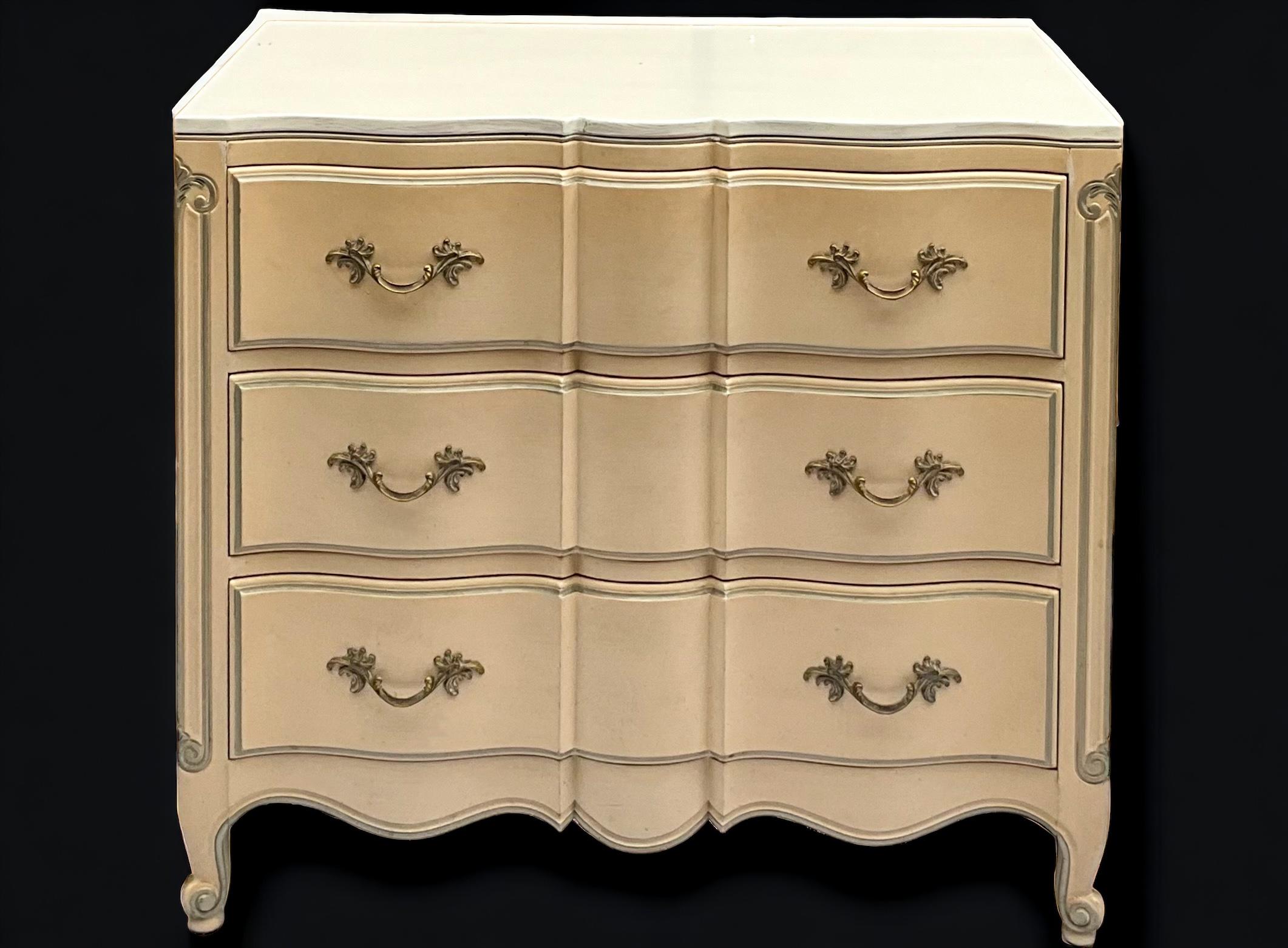 This is a timeless pair of French Louis XIV style chests with a custom finish by Dixie Furniture. The body is a blush with gray trim and ivory tops. They are marked with dovetail construction. They are in very good condition.