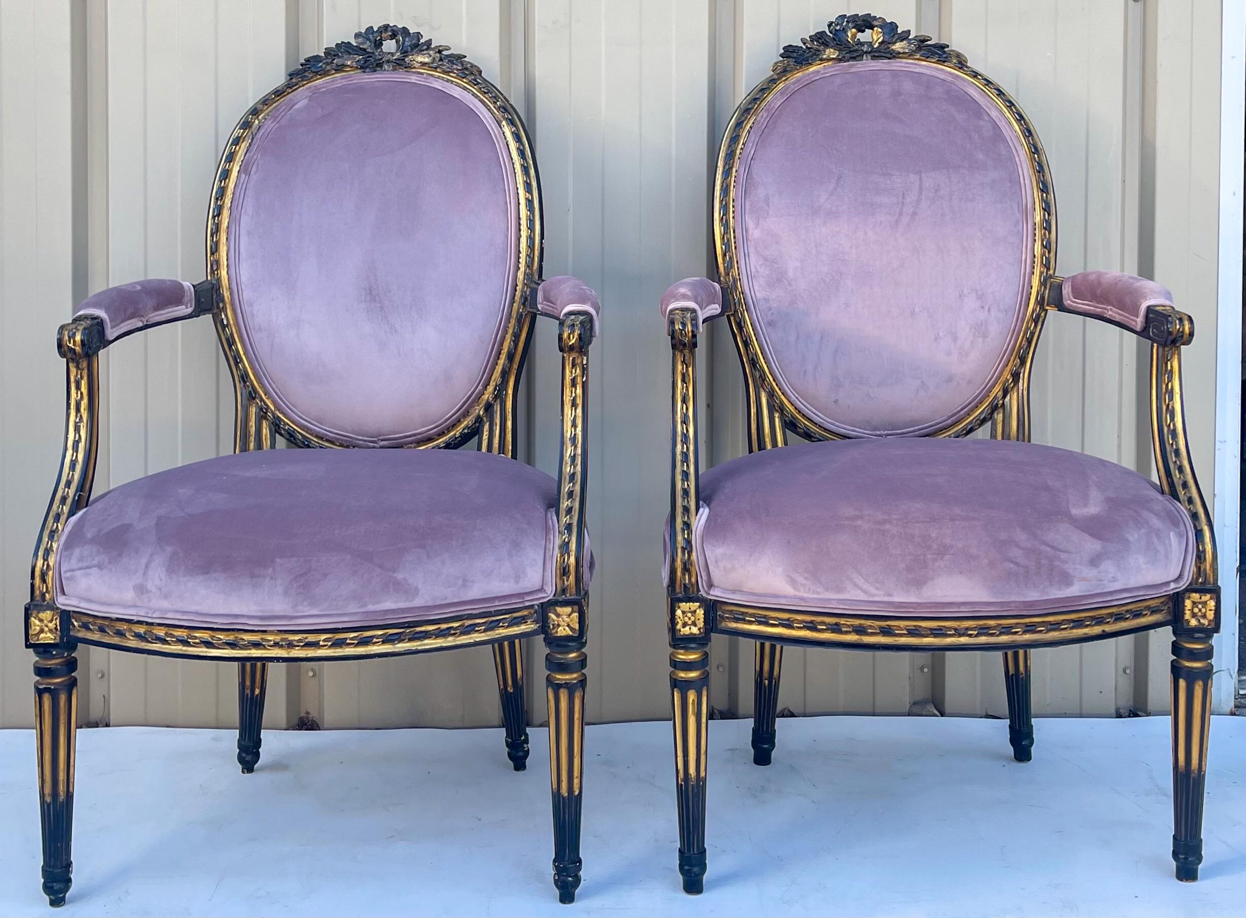 This is a pair of late 19th century French ebonized and parcel-gilt bergère chairs. They have Louis XIV styling. The lavender velvet upholstery is a recent addition. The ebonized and gilt frames are nicely carved. They are in very good condition.