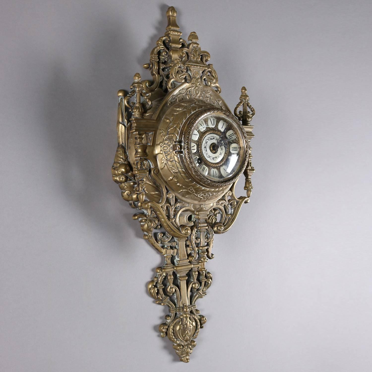 French Louis XIV style cartel wall clock by Tiffany & Co. features pierced scroll and foliate gilt bronze case with porcelain face having Roman numerals, en verso signed/stamped Tiffany & Co., clock in working condition, chimes and with key, 20th