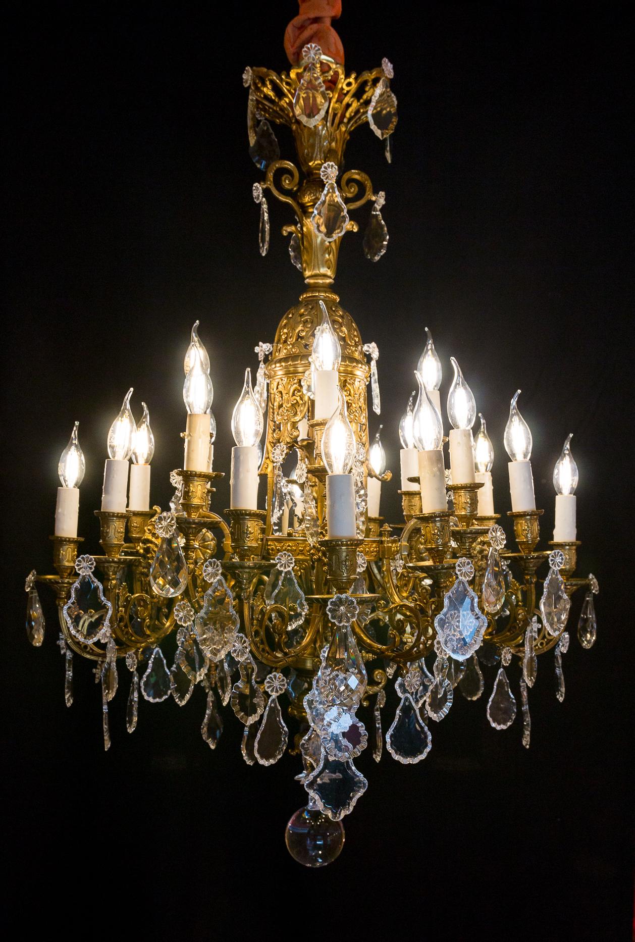 We are pleased to introduce you, a decorative chandelier in bronze chiseled and gilded, in the classic Louis XIV style. 

Our chandelier offers a finely carved decor of flowers, foliage, and masks of grotesque, inside a chandelier a vase with a