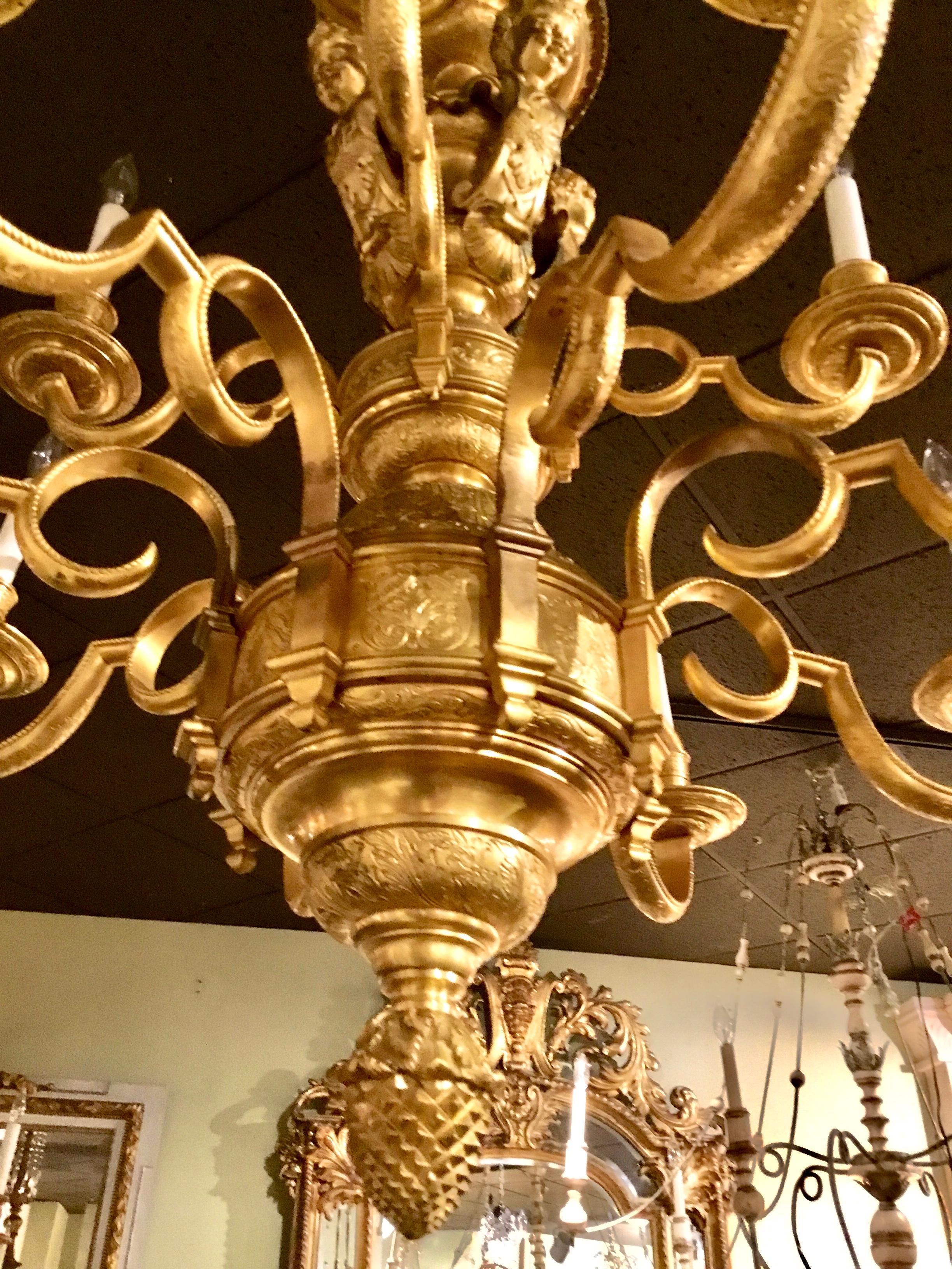 Exceptional gilding on this superb bronze chandelier with twelve-light.
Gilt bronze cherubs decorate the crest of this magnificent chandelier.
Scrolling arms that have engraving support the candles. The acorn finial
at the base is lovely!