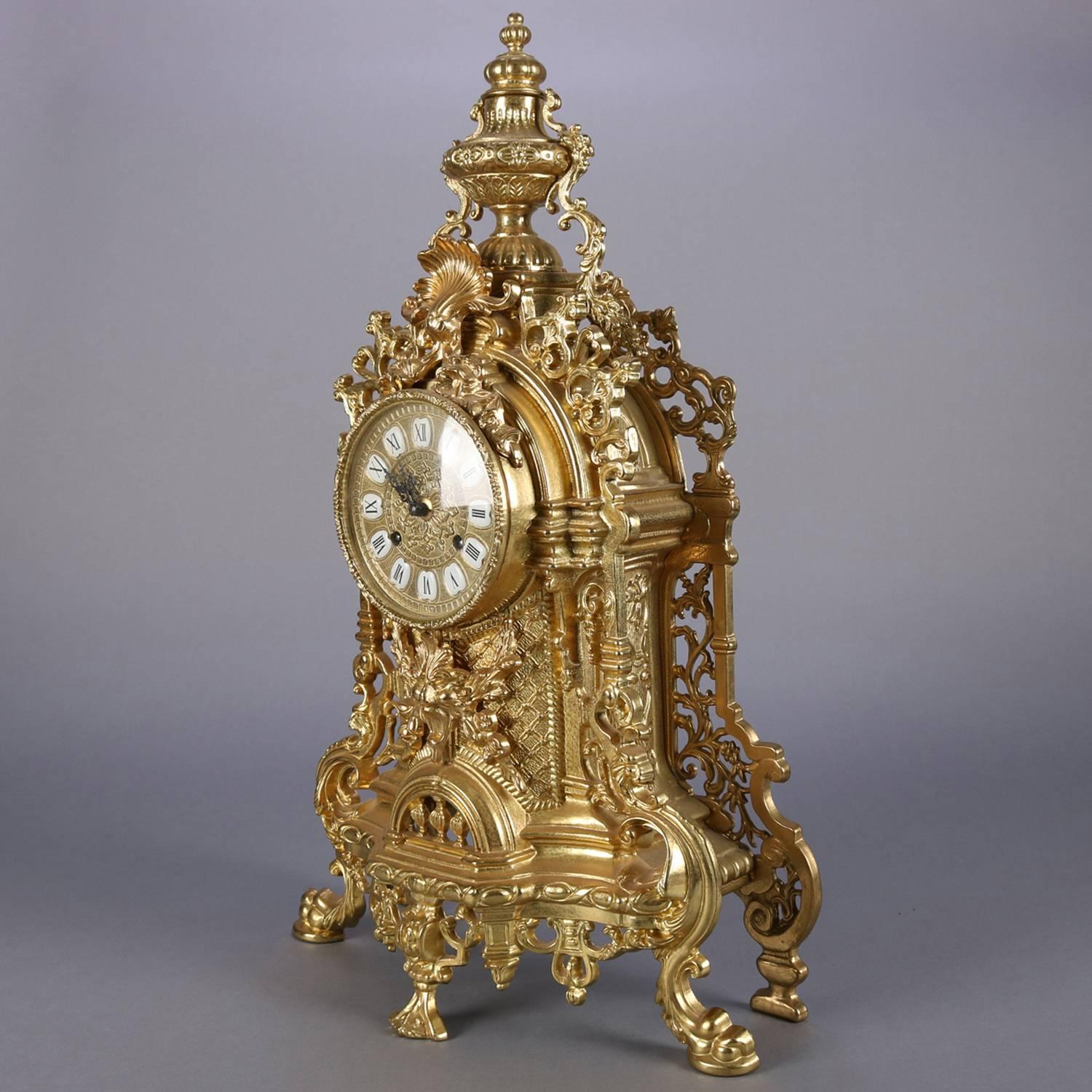 French Louis XIV style gilt mantel clock feature case made in Italy with pierced scroll and foliate design with central lion mask and urn form finial, dial with Roman numerals, German Works by FHS Hermele (Hermle), working and chimes on hour and