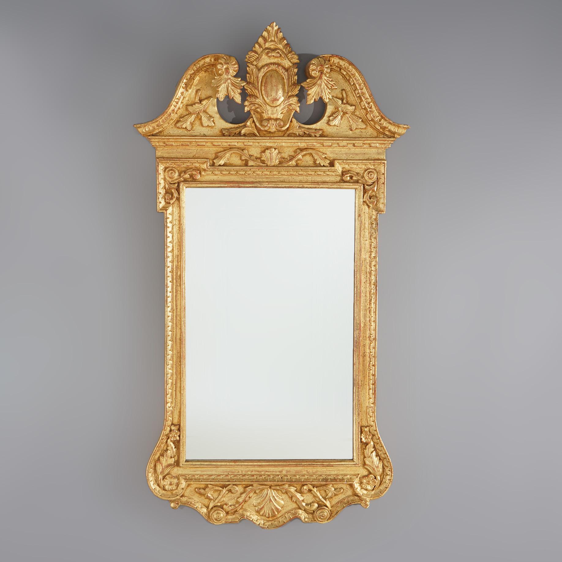 French Louis XIV style wall mirror features scroll and foliate broken arch pediment with central shield, lower with scroll and foliate apron with central shell and flanking scroll form corners, 20th century

Measures: 52