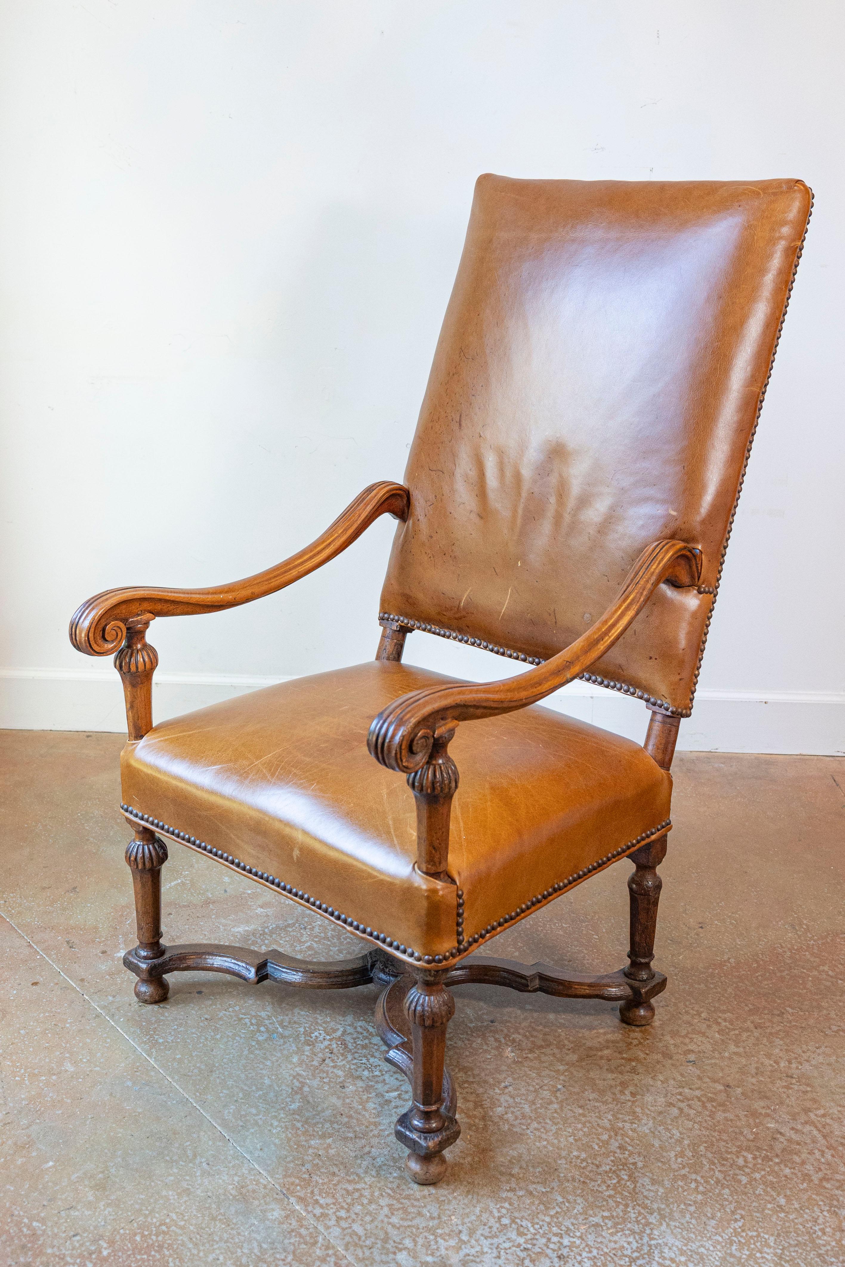 Fauteuil francese in legno di faggio in stile Luigi XIV, risalente alla fine del XIX secolo, con imbottitura in pelle, braccioli a spirale e barella a X. Nata in Francia nell'ultimo quarto del XIX secolo, questa squisita poltrona in legno di faggio