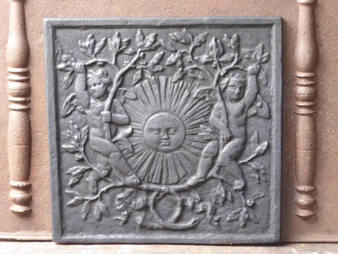 French Louis XIV style fireback with the sun surrounded by two cupids and olive branches. The sun symbolizes King Louis XIV, the Sun King, and the olive branches stand for peace.