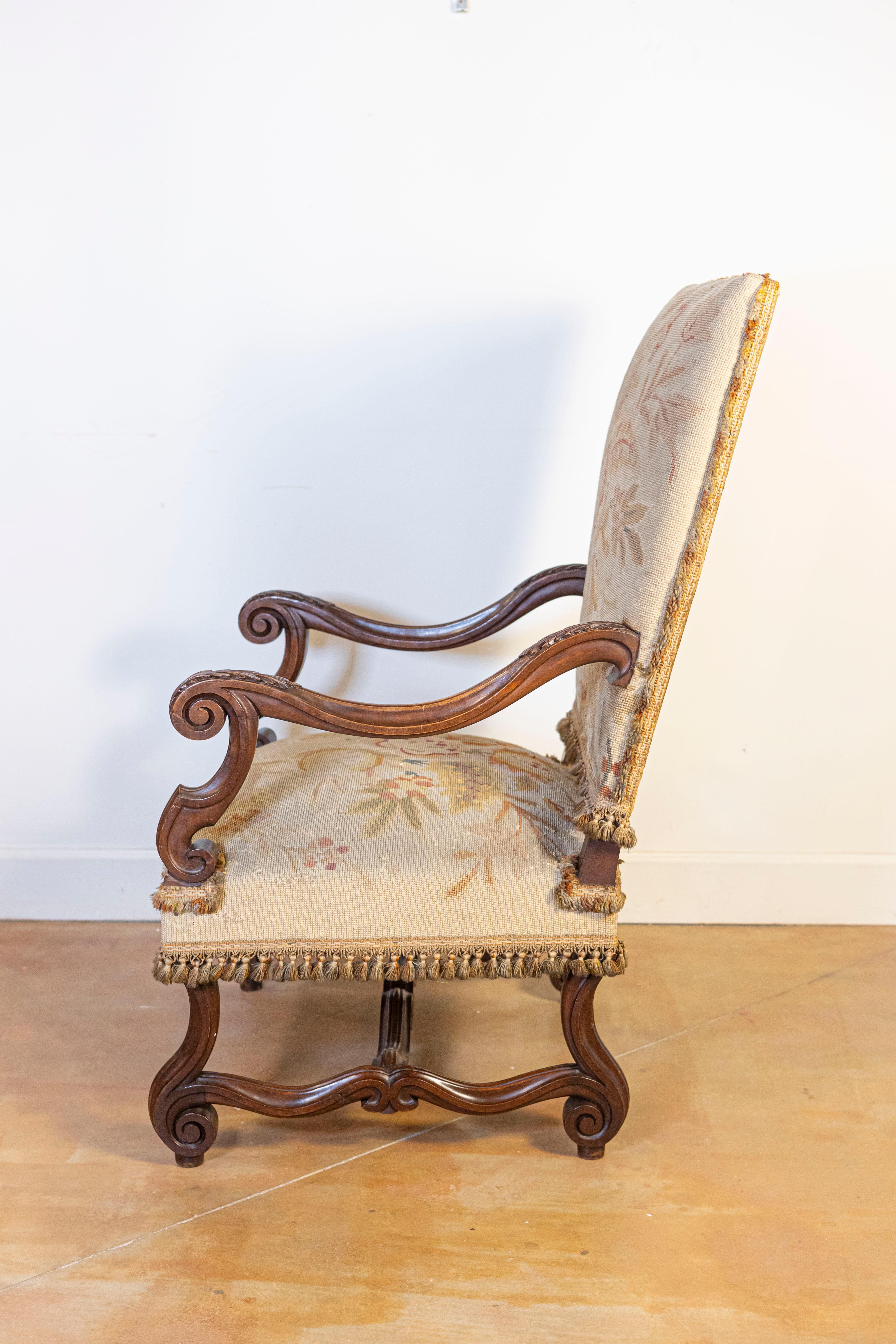 Fauteuil francés de nogal estilo Luis XIV con brazos tallados y patas con roleos Tallado en venta