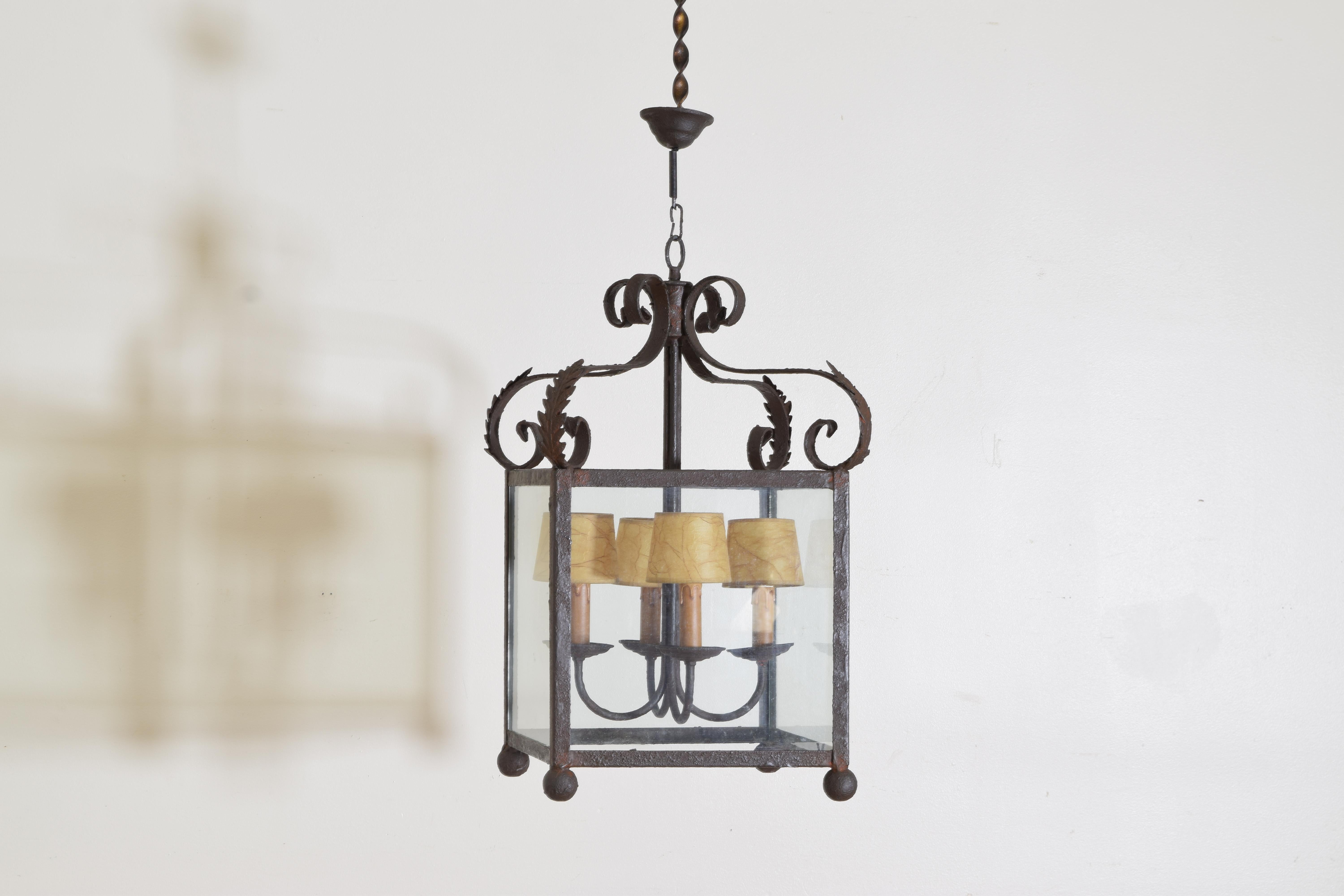 Hanging from a central ring the top with four scroll supports each with applied metal leaves, the body 4 sided with ball feet, retaining original 4-light cluster, standard wiring included in price, UL wiring available for an additional $350