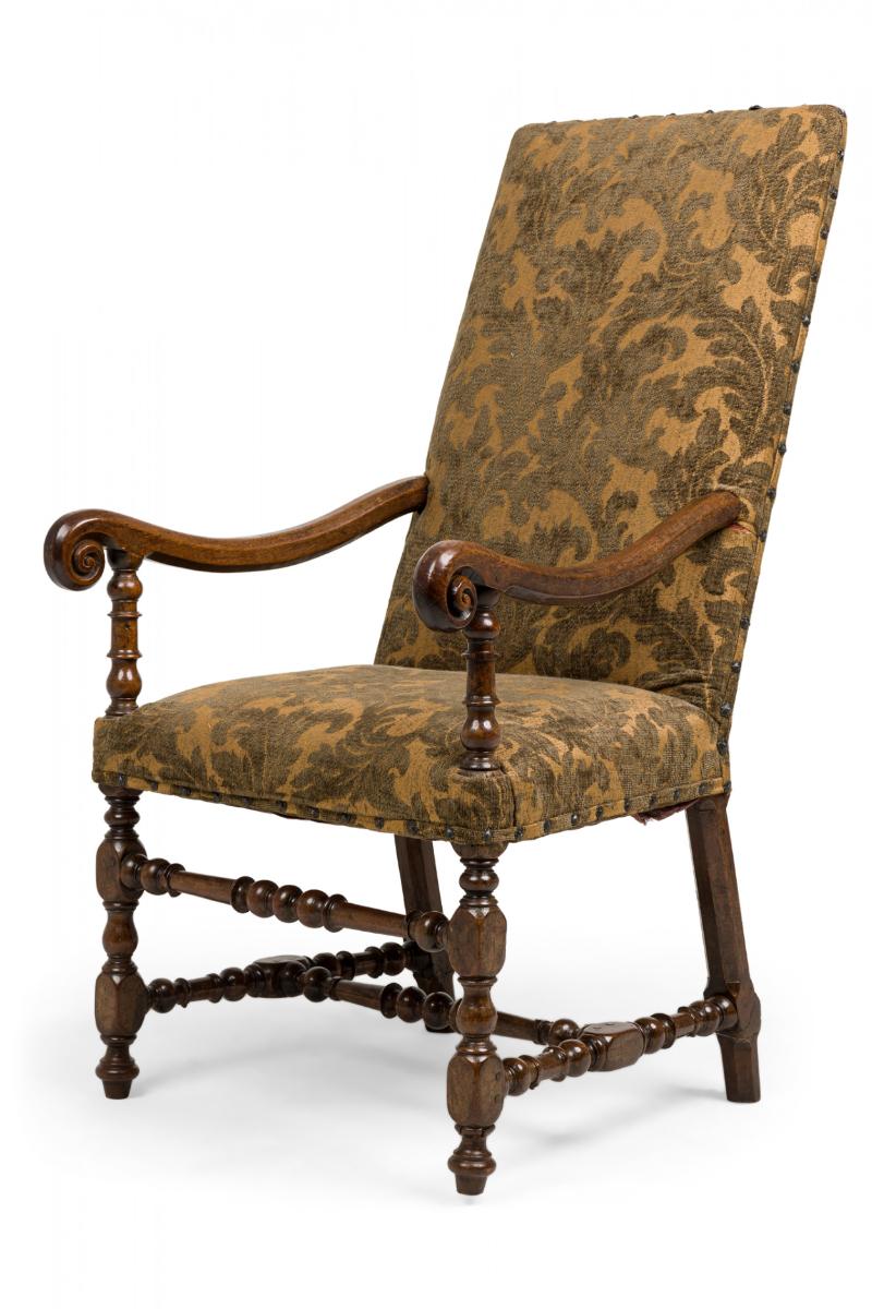 French Louis XIV (17th Century) carved walnut armchair with intricately turned front legs and stretchers, a gently sloped high back and concave downturned scroll arms, upholstered in a mossy green foliate tapSetry upholstery stylishly highlighted by