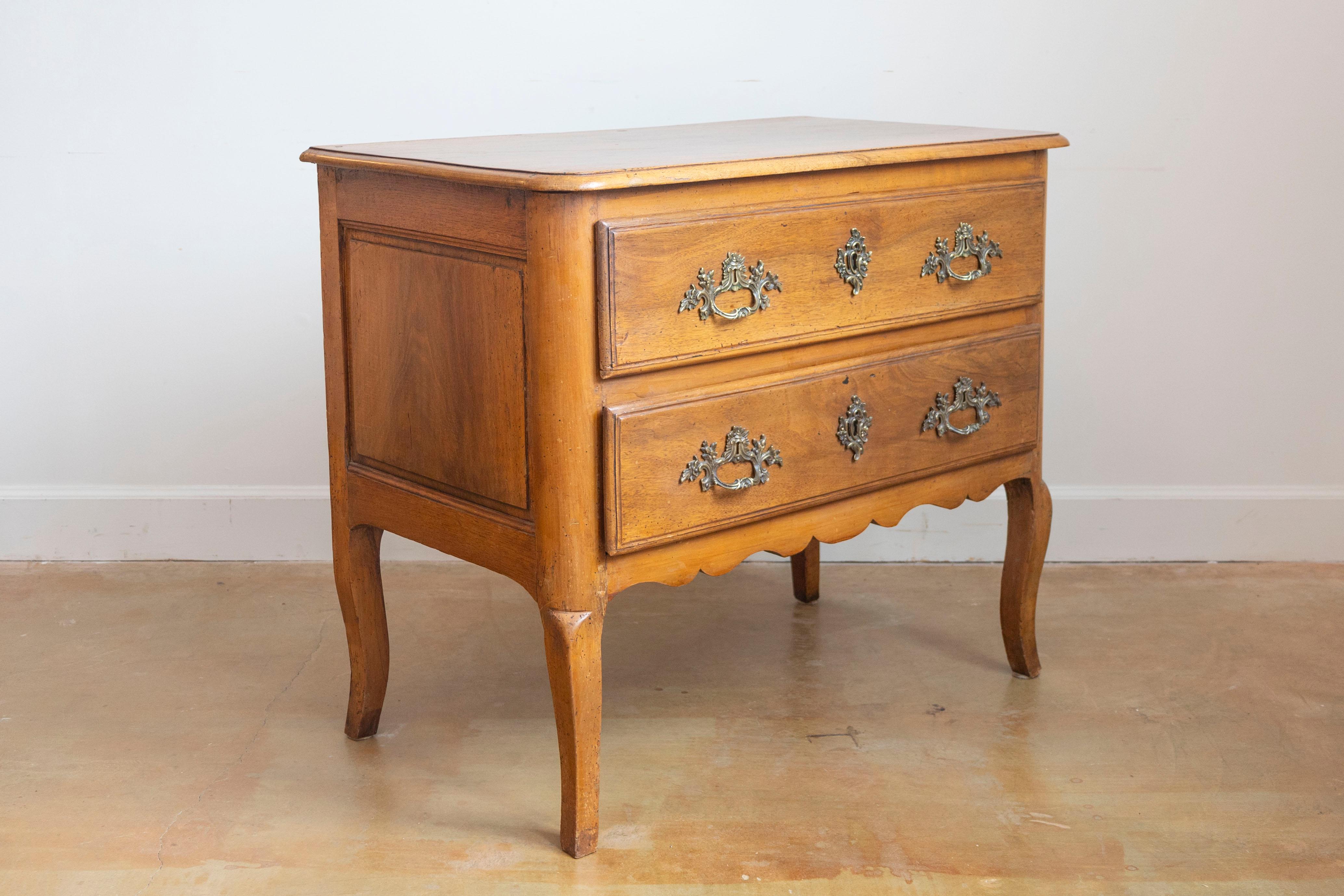 Commode Sauteuse in noce Luigi XV della fine del XVIII secolo, con due cassetti, ferramenta rococò in bronzo, gambe a cabriola e proporzioni ridotte. Creata alla fine del regno dell'ultimo monarca assoluto di Francia, Luigi XVI, nell'ultimo decennio
