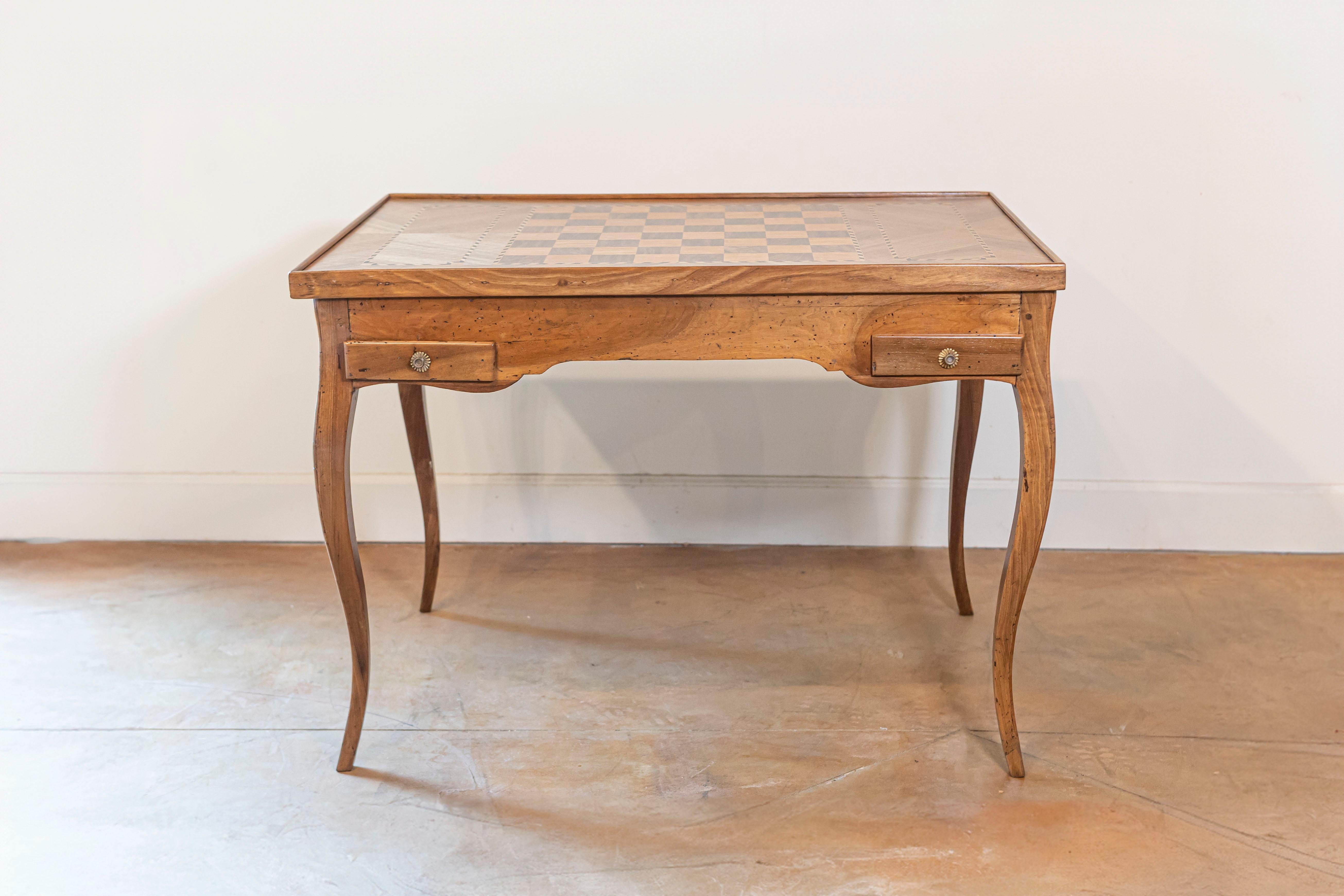 A French Louis XV tric trac game table from circa 1790 made of walnut and walnut veneer, with reversible top, marquetry and cabriole legs. This exquisite French Louis XV tric trac game table, dating back to around 1790, is a testament to the