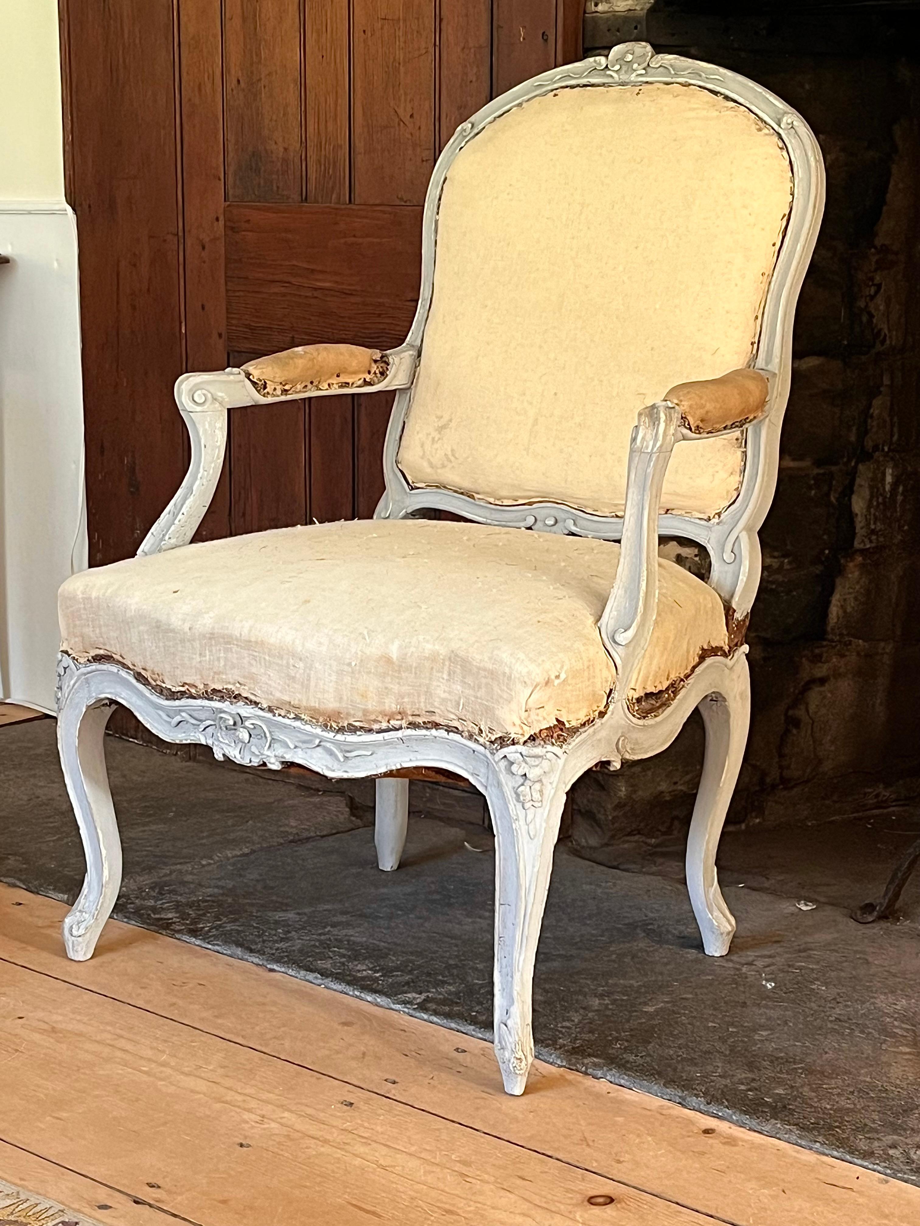 A French 18th century fauteuil a la reine, Louis XV period, in distressed grey painted finish, the frame carved with floral motifs, acanthus leaves at feet. Upholstered seat, back and arms. Nice scale and quality. 