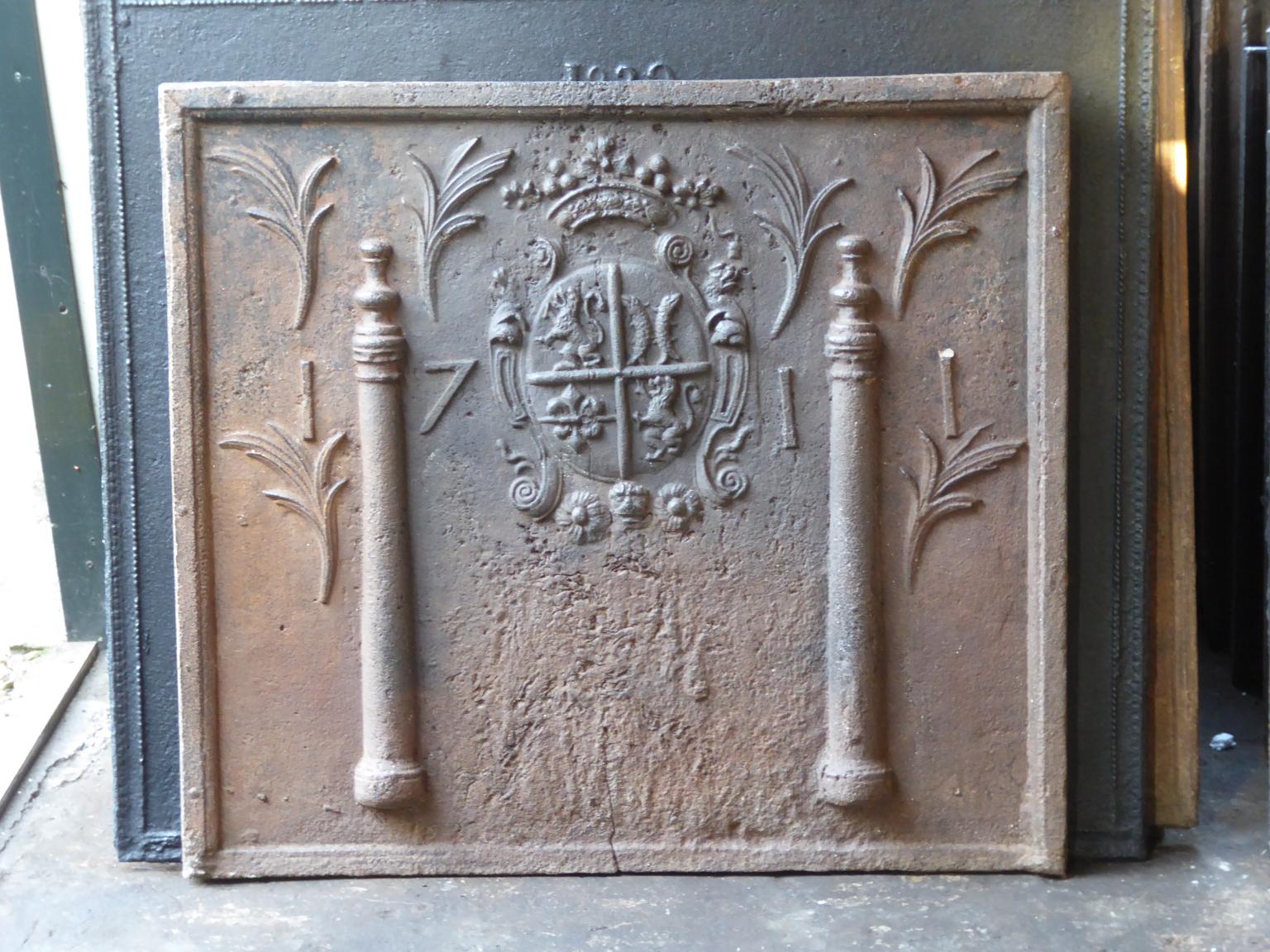 Beautiful 18th century French Louis XIV fireback with a coat of arms. The coat of arms is flanked by two Pillars of Hercules, which symbolize strength and the unknown. The date of production of the fireback, 1711, is also cast in the fireback. 

The