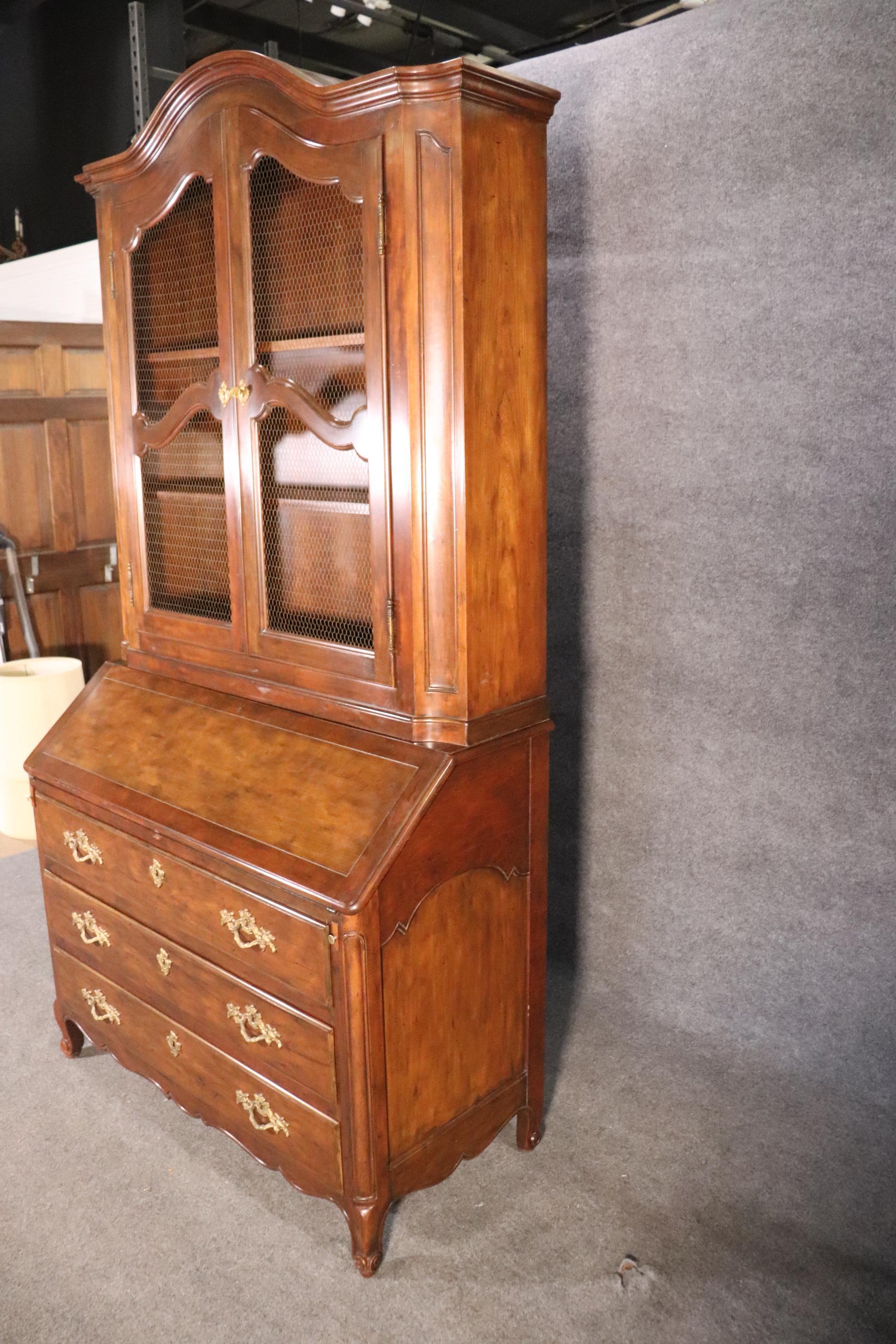 This is a rare item from Baker furniture. It's a French Louis XV style secretary desk in walnut with a mesh grill set for the doors. The desk measures 89 tall x 47 wide x 21 deep. The desk is in good vintage condition.
