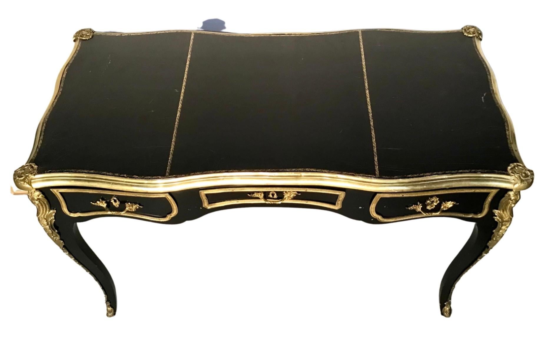French Louis XV Ebonized Black Lacquer Bronze Figural Ormolu Bureau Plat Writing Desk. Featuring finished back with three faux drawers, ornate bronze ormolu, bronze feet, 3 panel tooled leather top, bronze ormolu mounts to legs, black lacquer