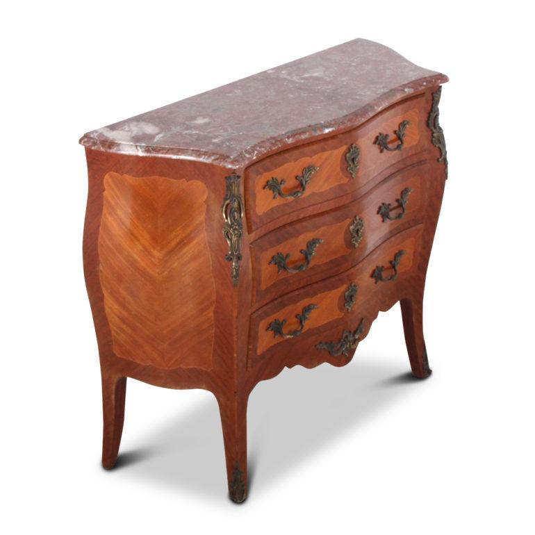 A French, early 20th century, three-drawer commode of ‘bombe’ form, the case and drawers elaborately veneered in kingwood and mahogany and with ornate Louis XV-style mounts and retaining its original marble top, circa 1930.



   