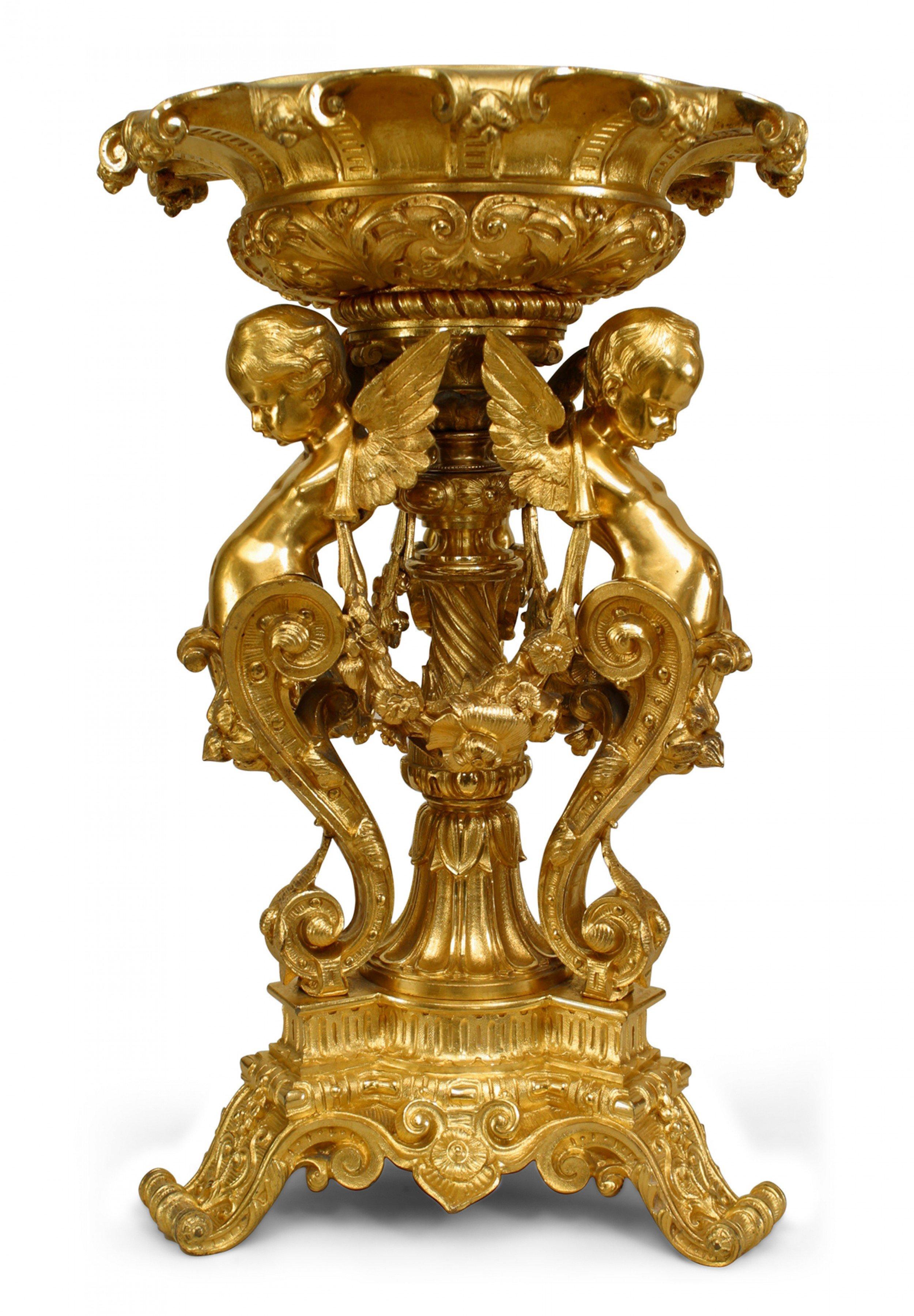French Louis XV-style (19th Century) bronze dore triple cupid design centerpiece with swags between figures under a crystal round bowl with fluted gilt trim.
 