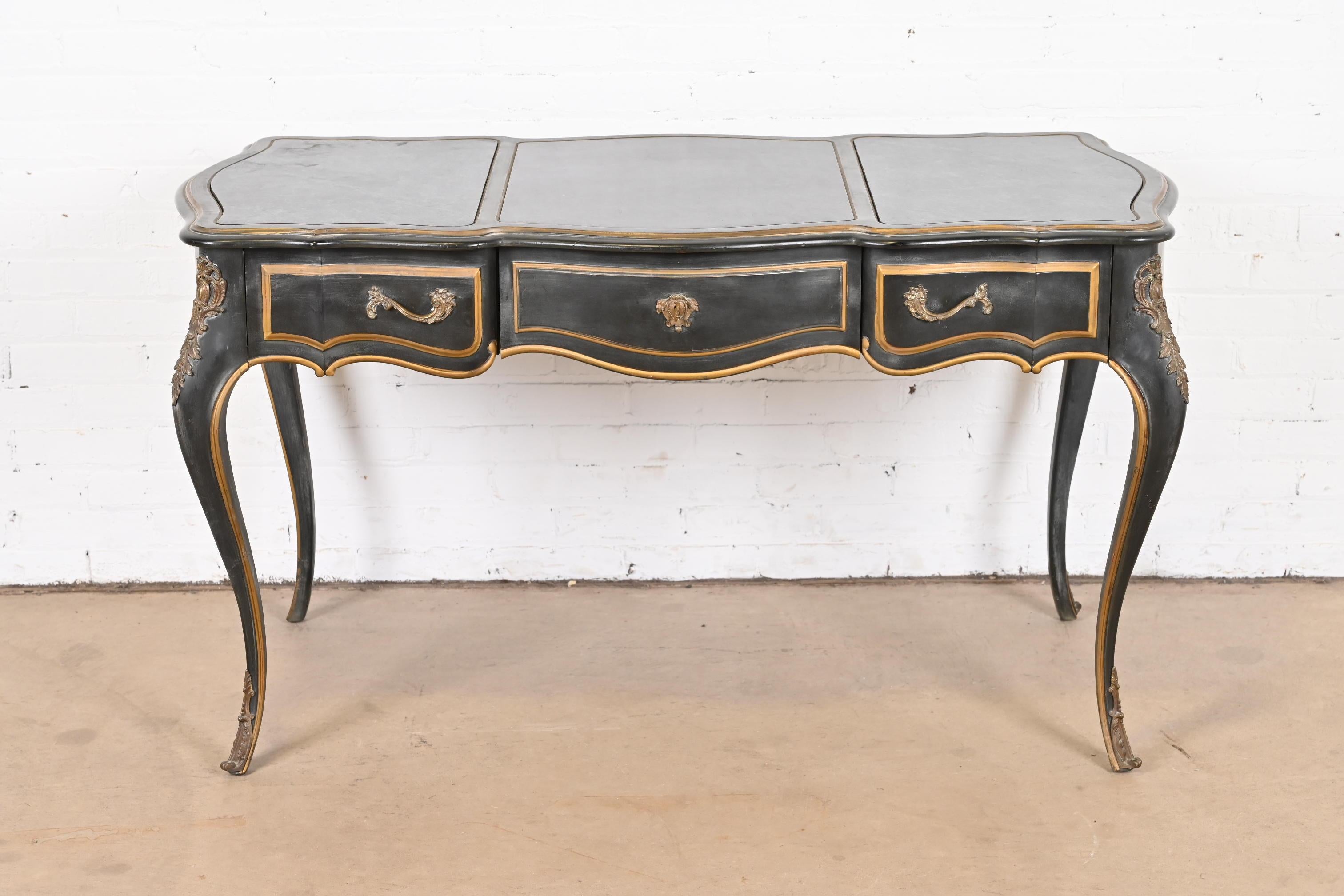 A gorgeous French Louis XV style bureau plat desk

By Drexel

USA, 1960s

Original antiqued navy lacquer finish, with gold gilt trim, mounted bronze ormolu, and faux marble laminate top.

Measures: 53
