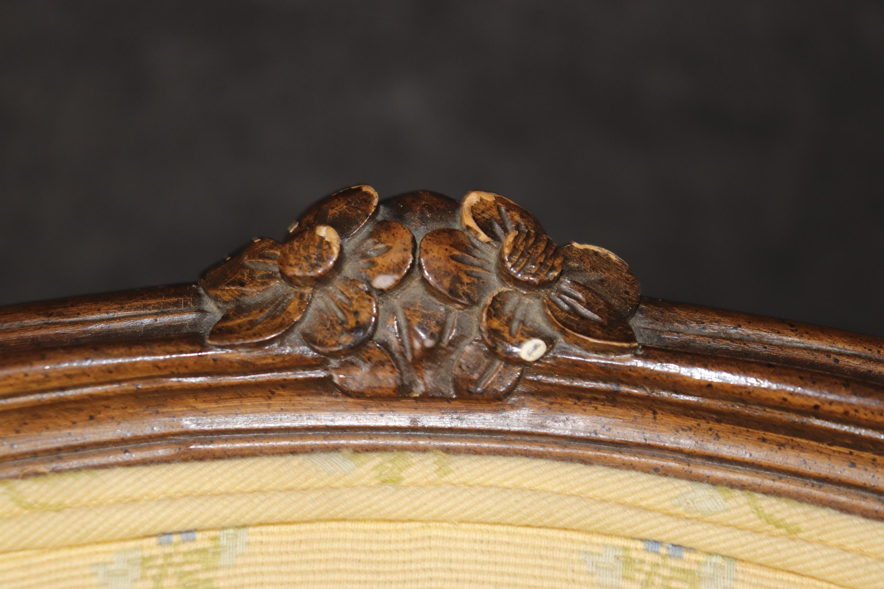 This is a clean pair of French Louis XV Style Bergere chairs in good condition with bright yellow upholstery with charming blue flowers embroidered into the upholstery. The frames are in good condition with minor signs of age and use and the fabric