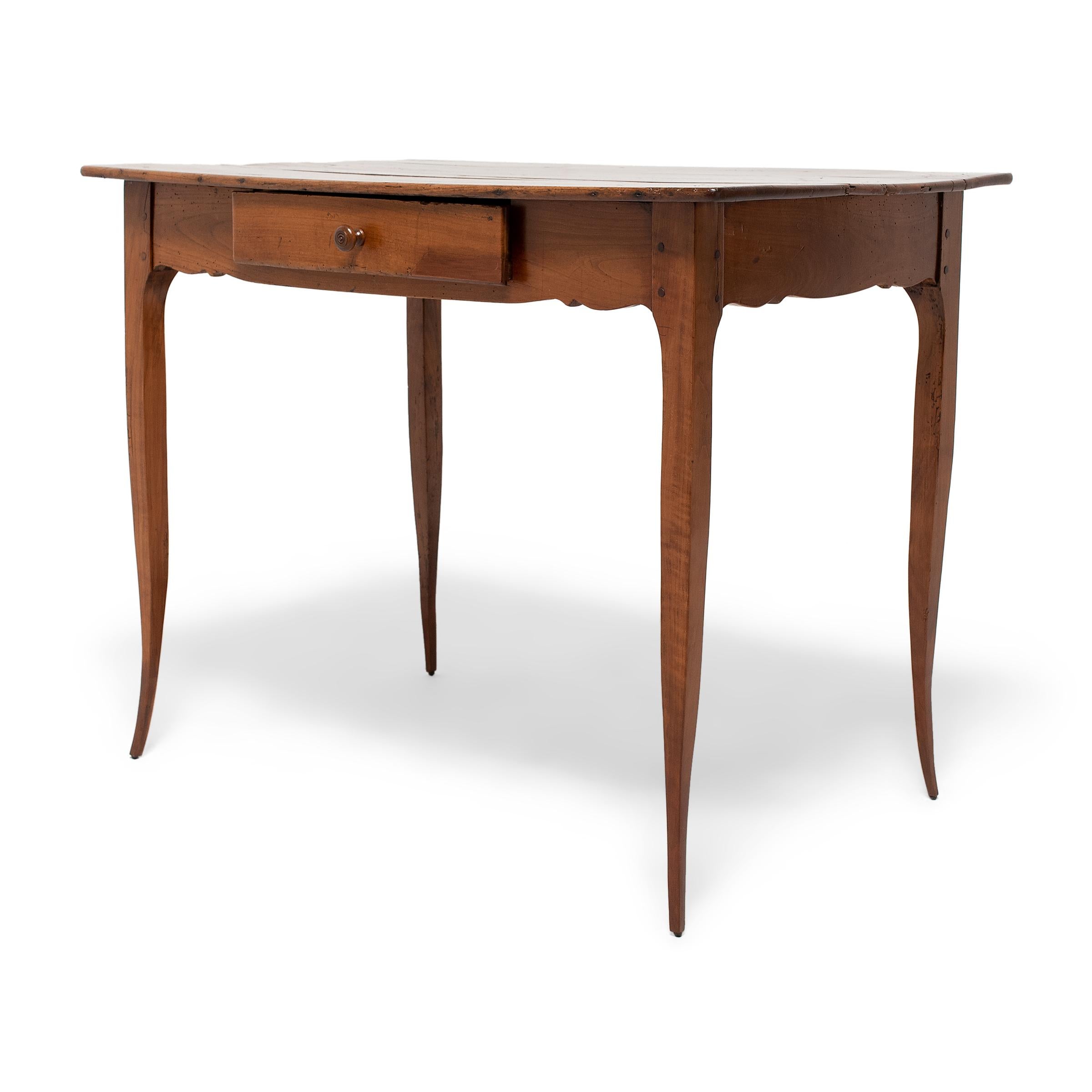 This refined Louis XV side table has an airy, lightweight design defined by slightly curving legs that taper dramatically to delicate, pointed feet. Crafted in France in the 18th century, the table has a thin, rectangular top comprised of three