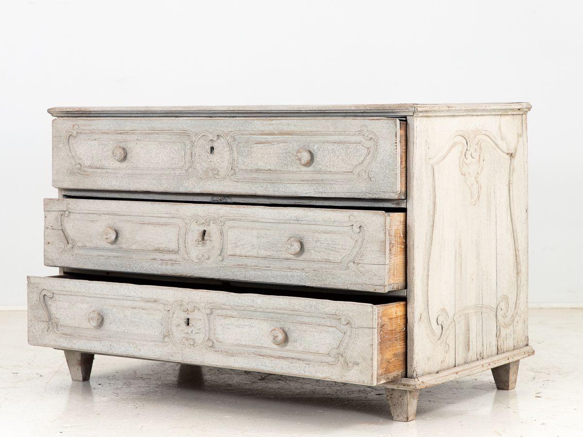 This captivating French 19th-century Louis XV commode is adorned with timeless elegance and exquisite craftsmanship. This remarkable piece features a graceful silhouette with three spacious drawers, providing ample storage for your belongings. The