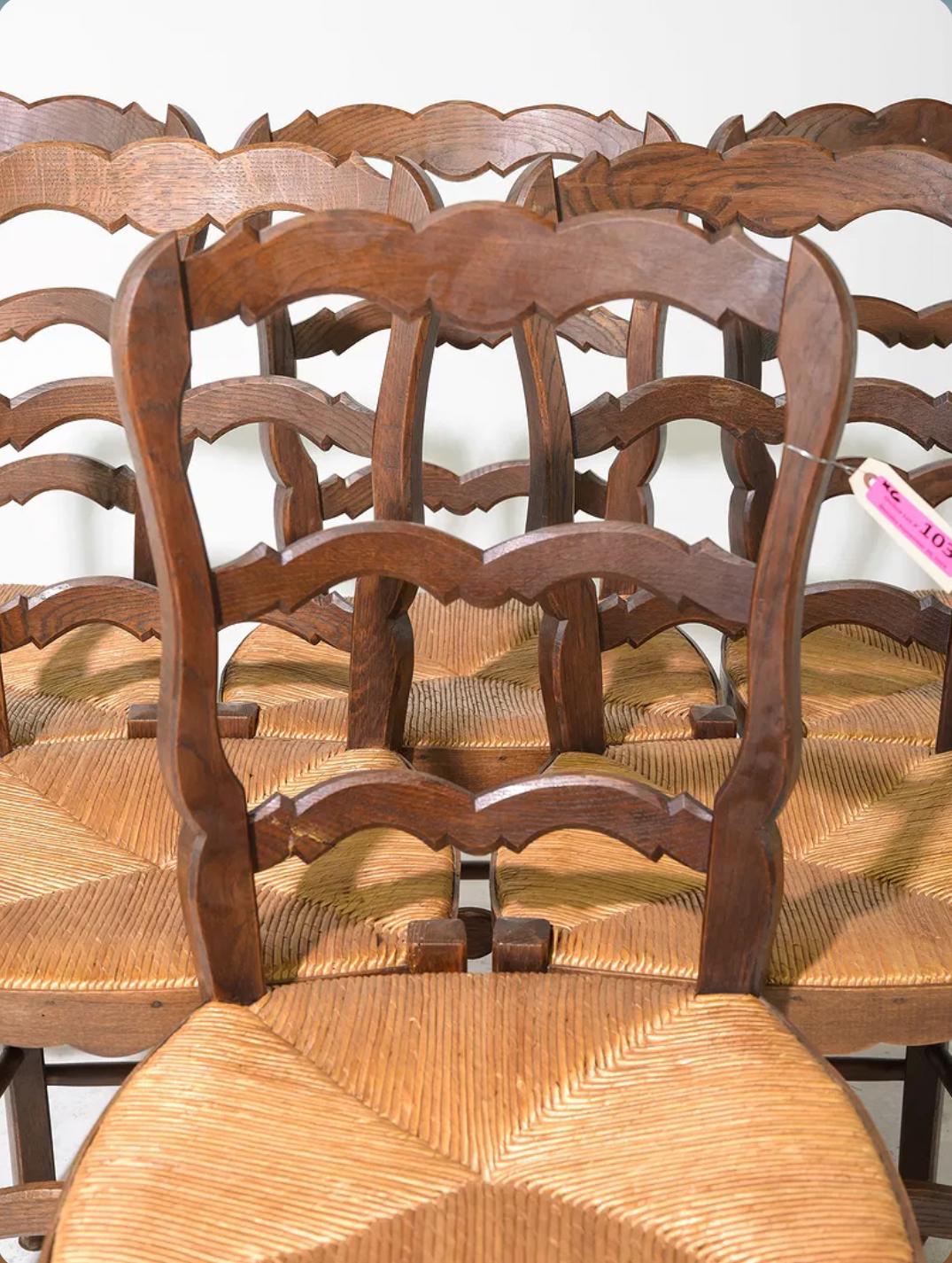Este encantador juego de seis sillas de comedor de roble presenta asientos clásicos de junco que se conservan en buen estado vintage. Las elegantes patas cabriolé se unen a una camilla torneada, combinando la artesanía tradicional con un confort
