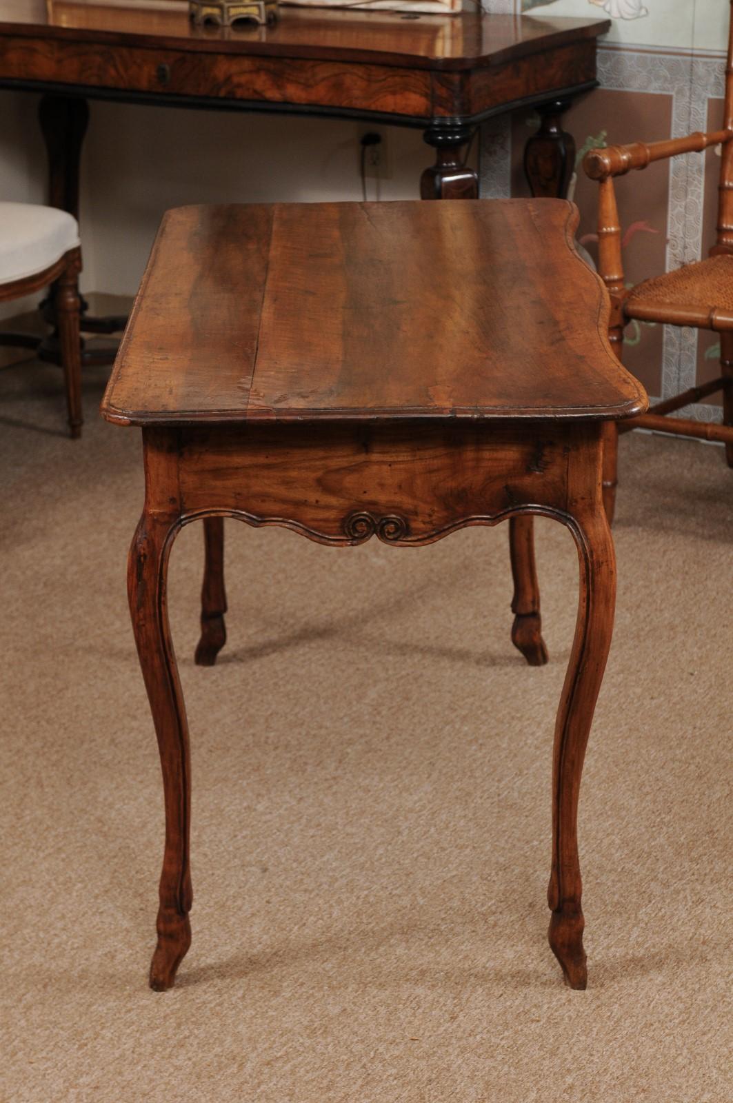 A French Louis XV fruitwood console table with 1-drawer, carved scalloped apron on front and sides. All resting on cabriole legs ending hoofed feet. The edge of the legs and apron with carved molded detail that give a more refined appearance. The