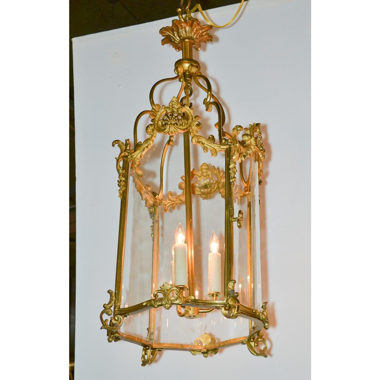 Splendid French Louis XV style gilt bronze and shaped glass hall, alcove, or entry lantern. Decorated with finely detailed gold-gilded bronze foliate swags and accented with acanthus leaves and shells. Beautiful leaf-spray bronze canopy,

circa